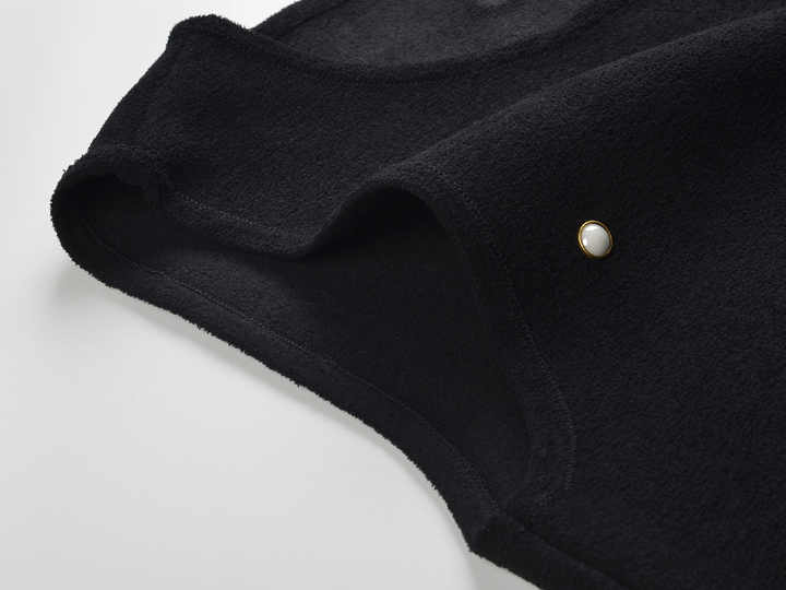 Sleeveless black mini dress featuring delicate pearl embellishments and a playful tiered ruffle skirt