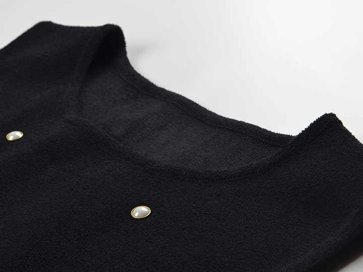 Sleeveless black mini dress featuring delicate pearl embellishments and a playful tiered ruffle skirt