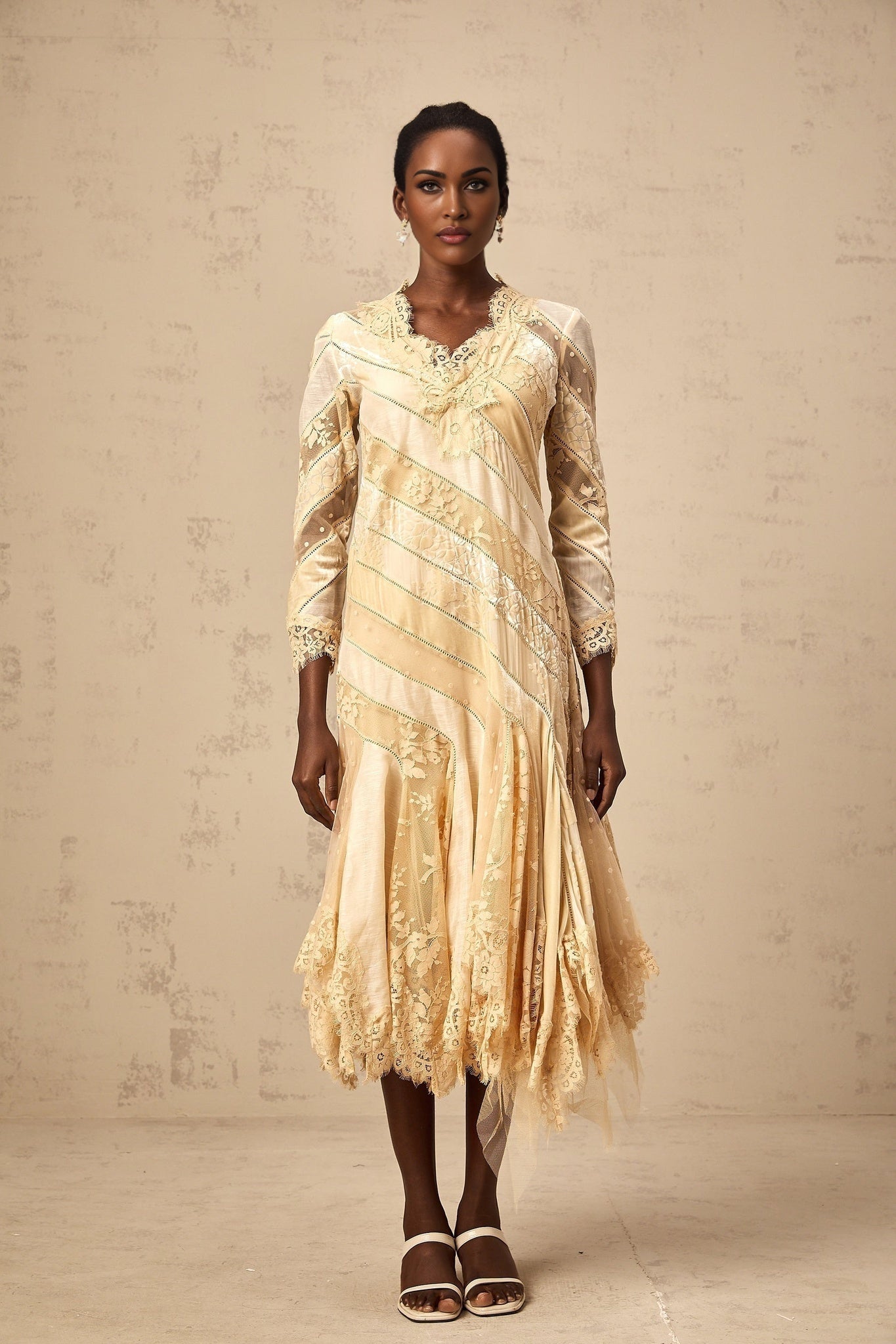 A beige midi dress with diagonal stripes and panel details named Ingrid