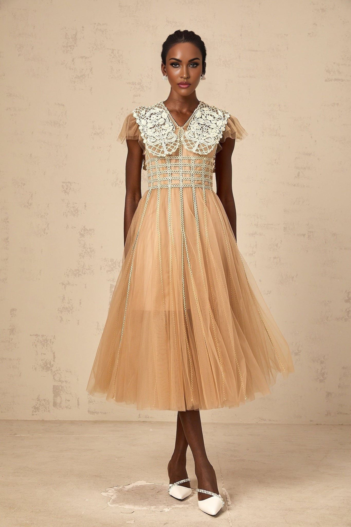 A beige tulle midi dress with delicate lace panels and a soft neutral color scheme