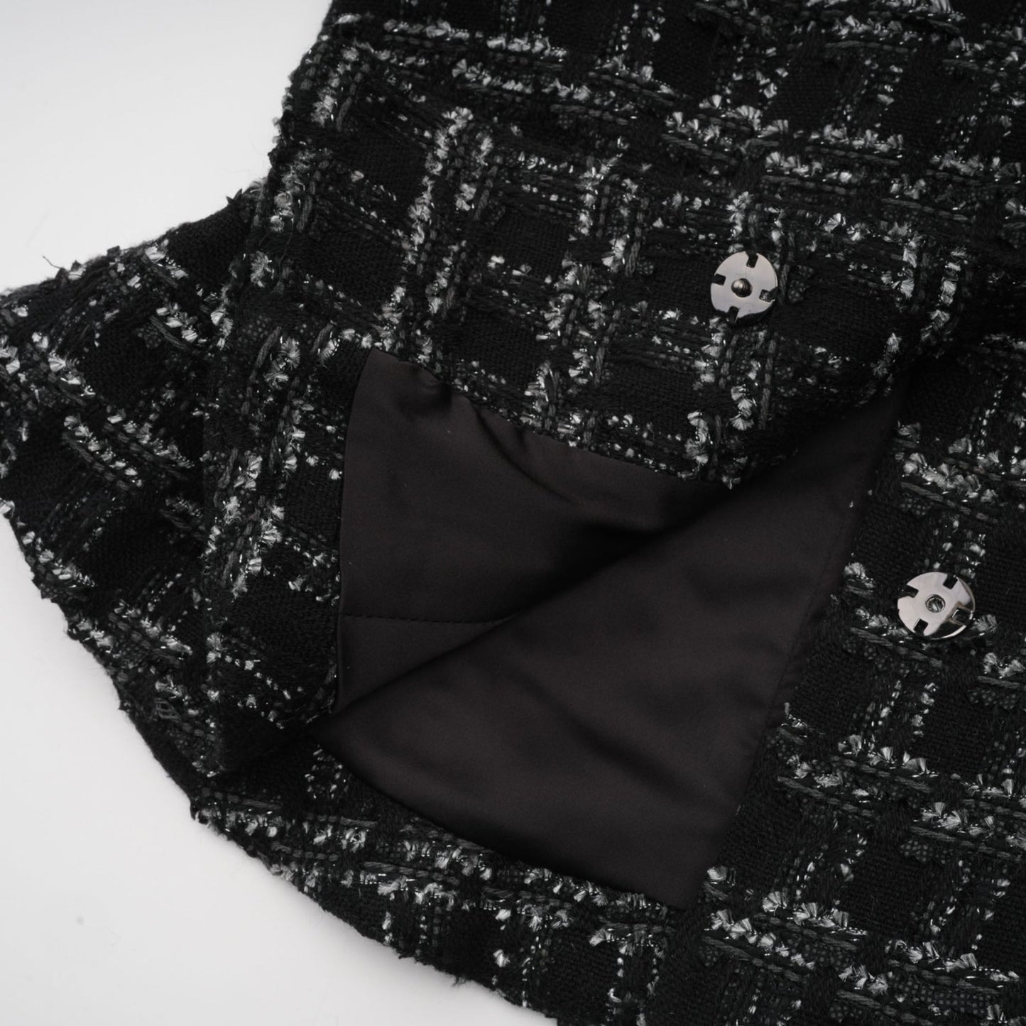 A black and white checked tweed matching set consisting of a sleeveless vest top and skirt in a classic pattern