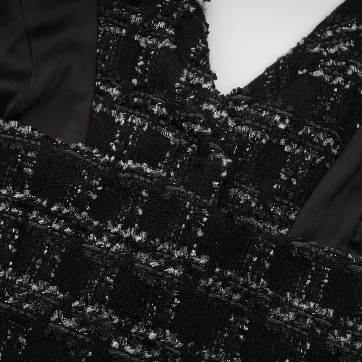 A black and white checked tweed matching set featuring a sleeveless vest top and skirt in a classic pattern