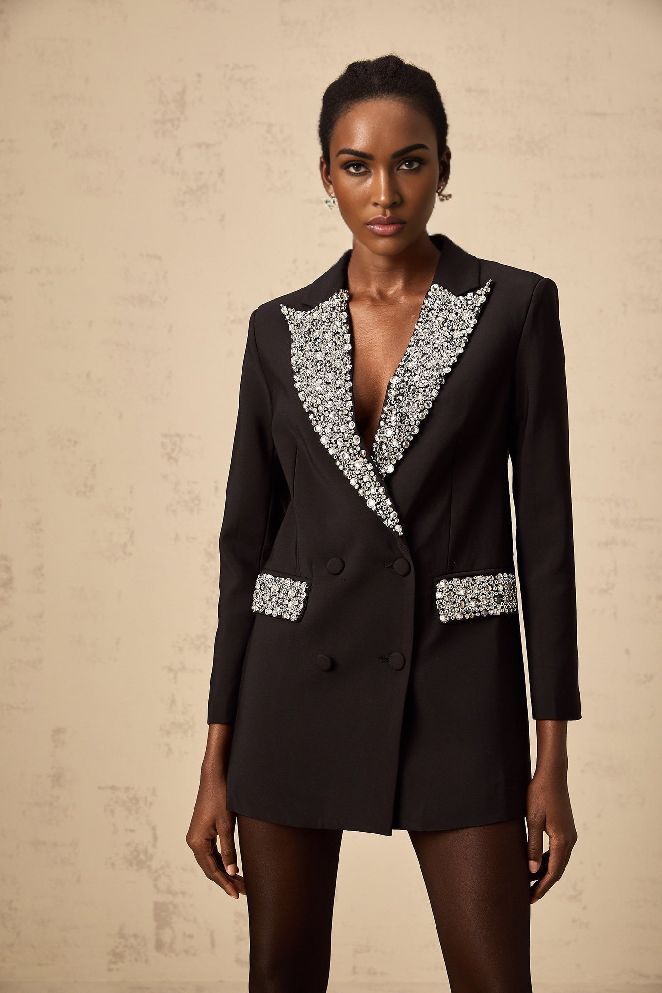 A black blazer adorned with crystal embellishments featuring a tailored silhouette and sparkling details