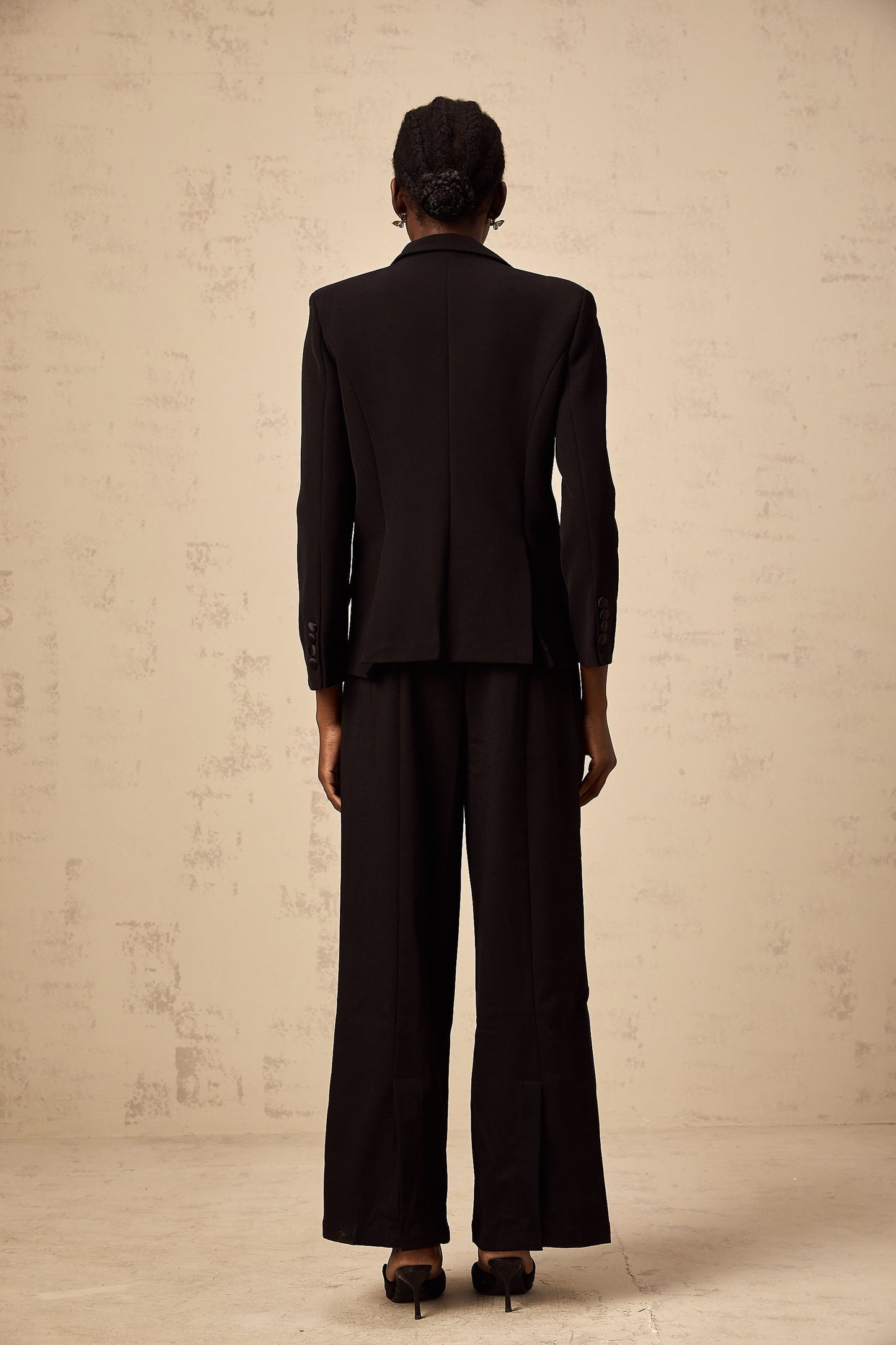 A black blazer adorned with intricate bead embroidery featuring the name Ximena