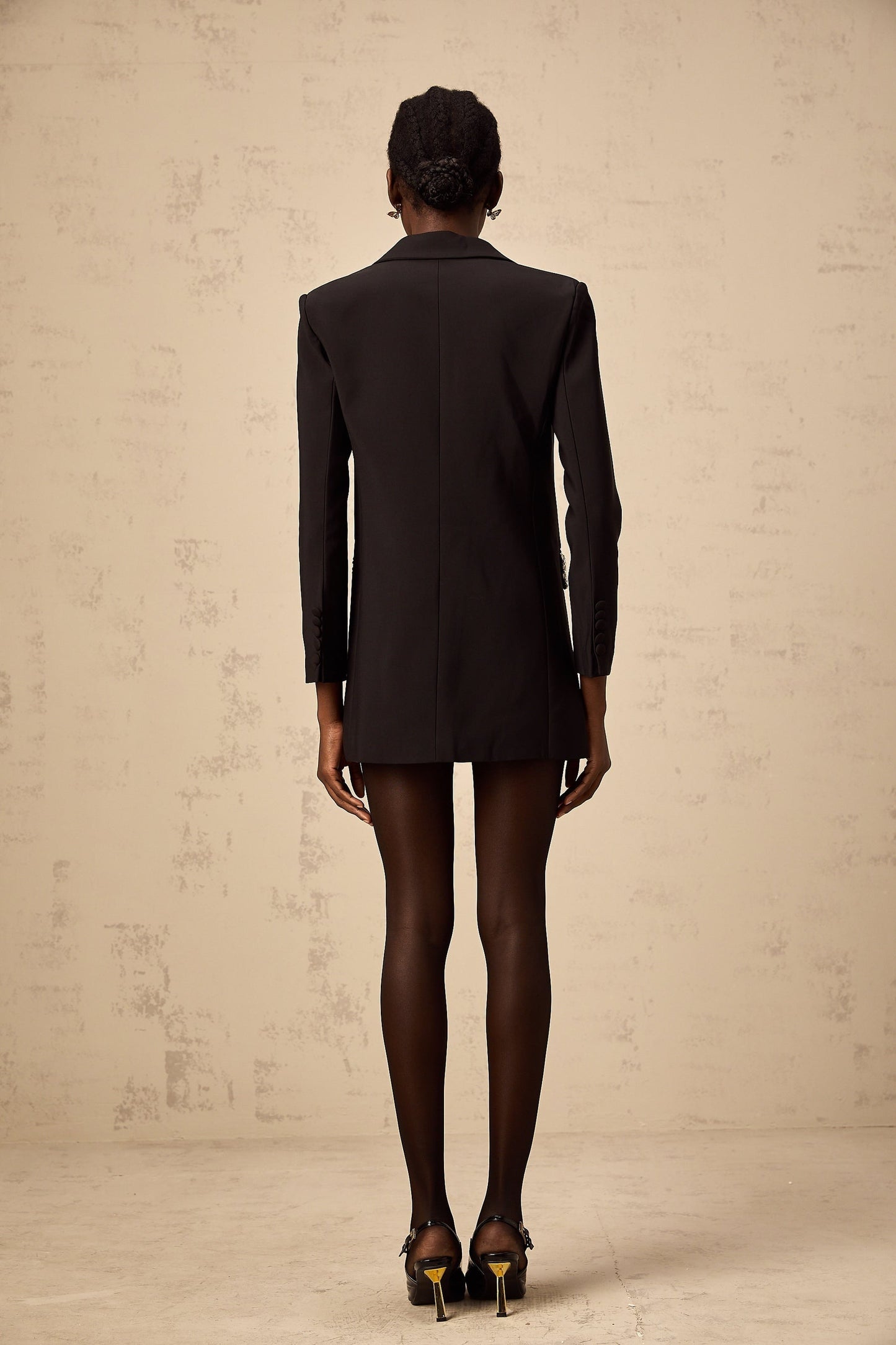 A black blazer adorned with sparkling crystal embellishments featuring a tailored fit and elegant design