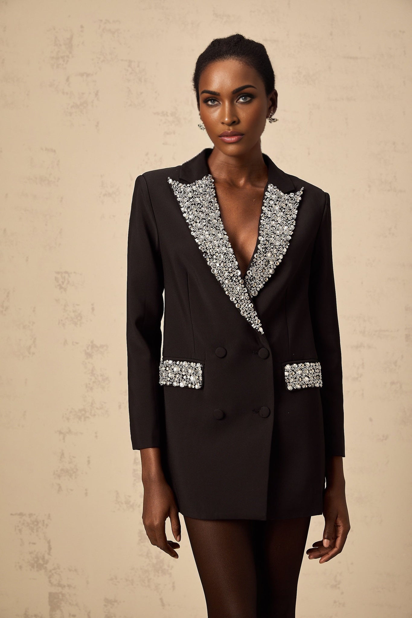 A black blazer adorned with sparkling crystal embellishments featuring a tailored fit and elegant design