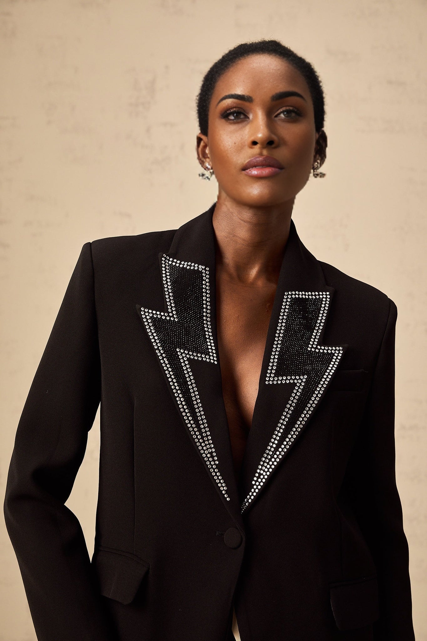 A black blazer with crystal embellishments in the shape of lightning bolts
