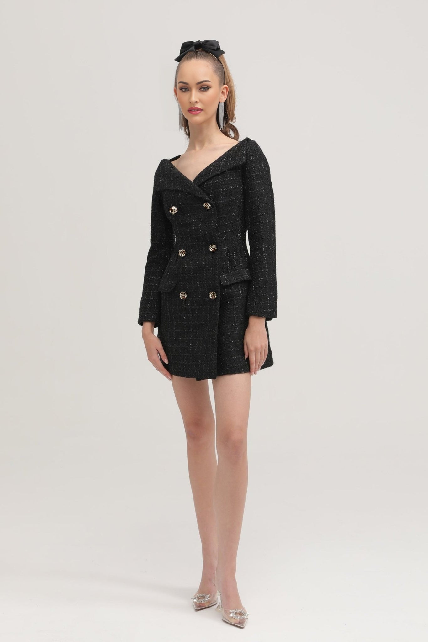 A black doublebreasted coat dress named Erin worn by a model against a plain background