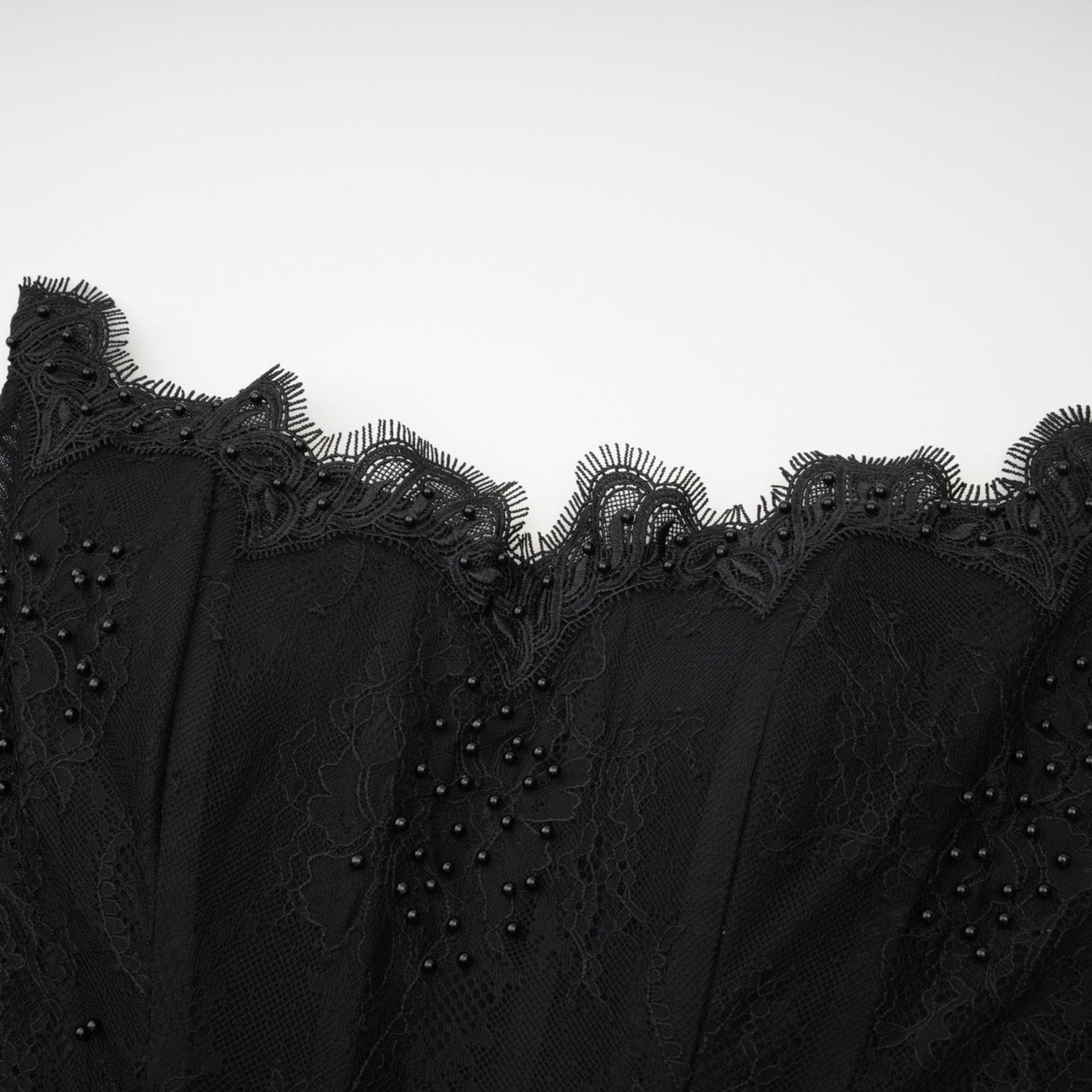 A black off the shoulder dress with mesh lace pearls ribbon and lace hem at a flattering mini length made of 95% polyester 5% elastane