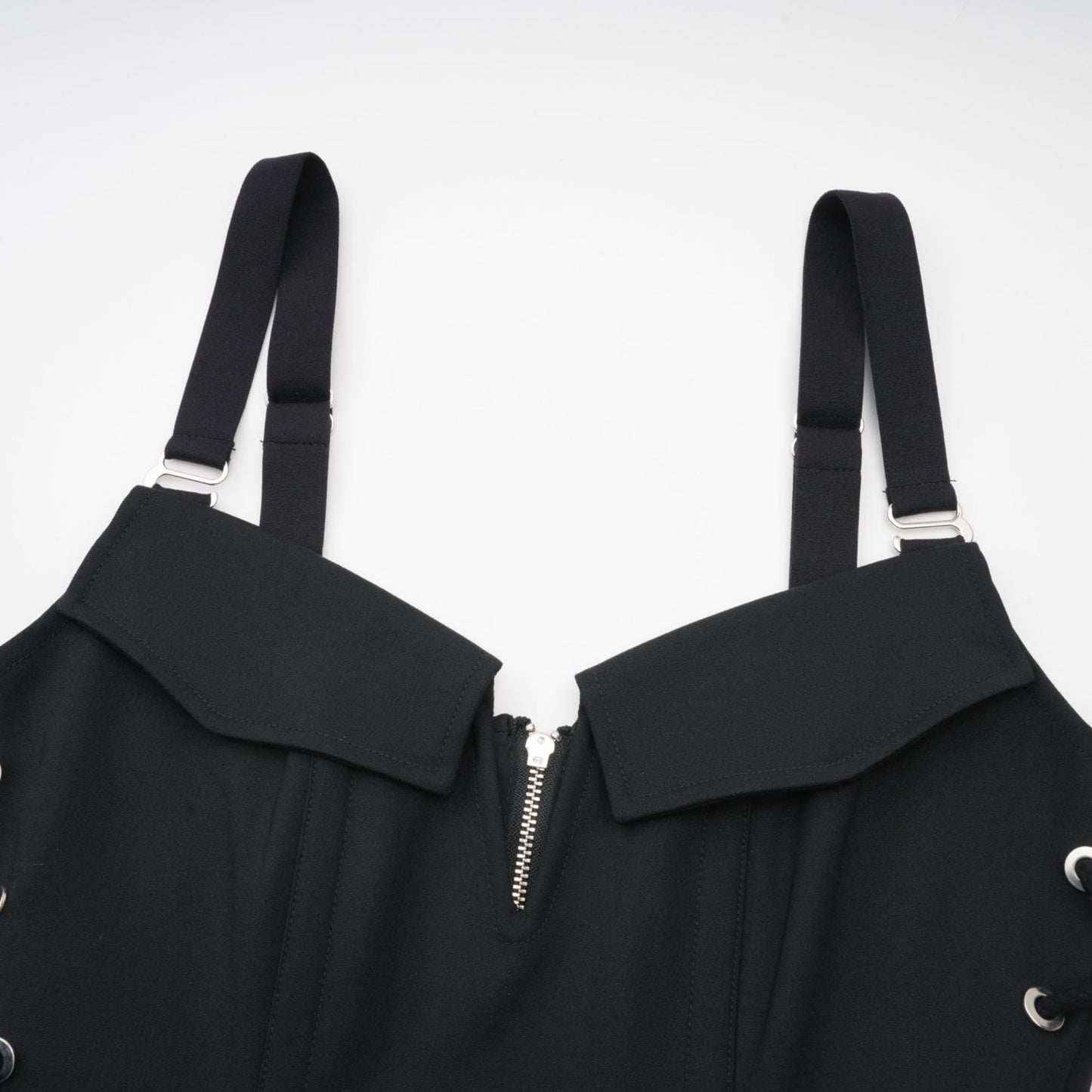 Sleeveless black dress with Vneck boned bodice adjustable straps rear zip hook closure flap pockets thighlength 98% Organic Cotton 2% Elastane