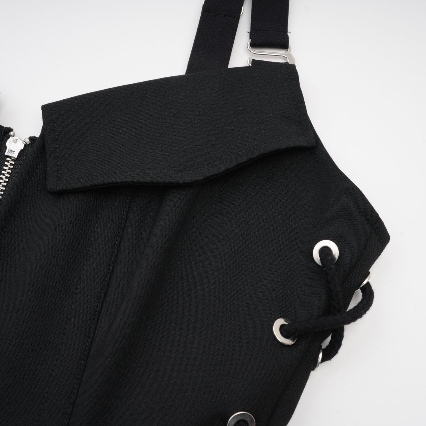 Black sleeveless dress with a Vneck and structured boned bodice Adjustable and detachable shoulder straps stylish chest flap pockets and thighlength coverage Made of 98% Organic Cotton and 2% Elastane Wrapped in designer rear zip and side hook and eye closure