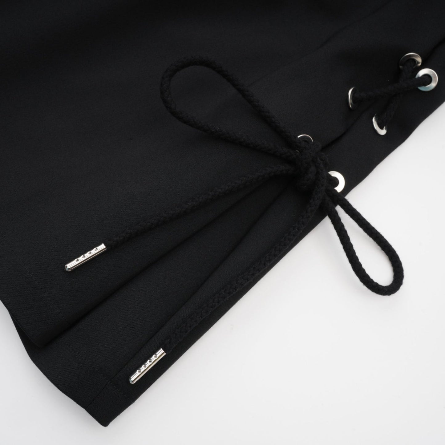 Black sleeveless dress with Vneck boned bodice adjustable straps rear zip chest pockets and thighlength coverage in organic cotton and elastane blend