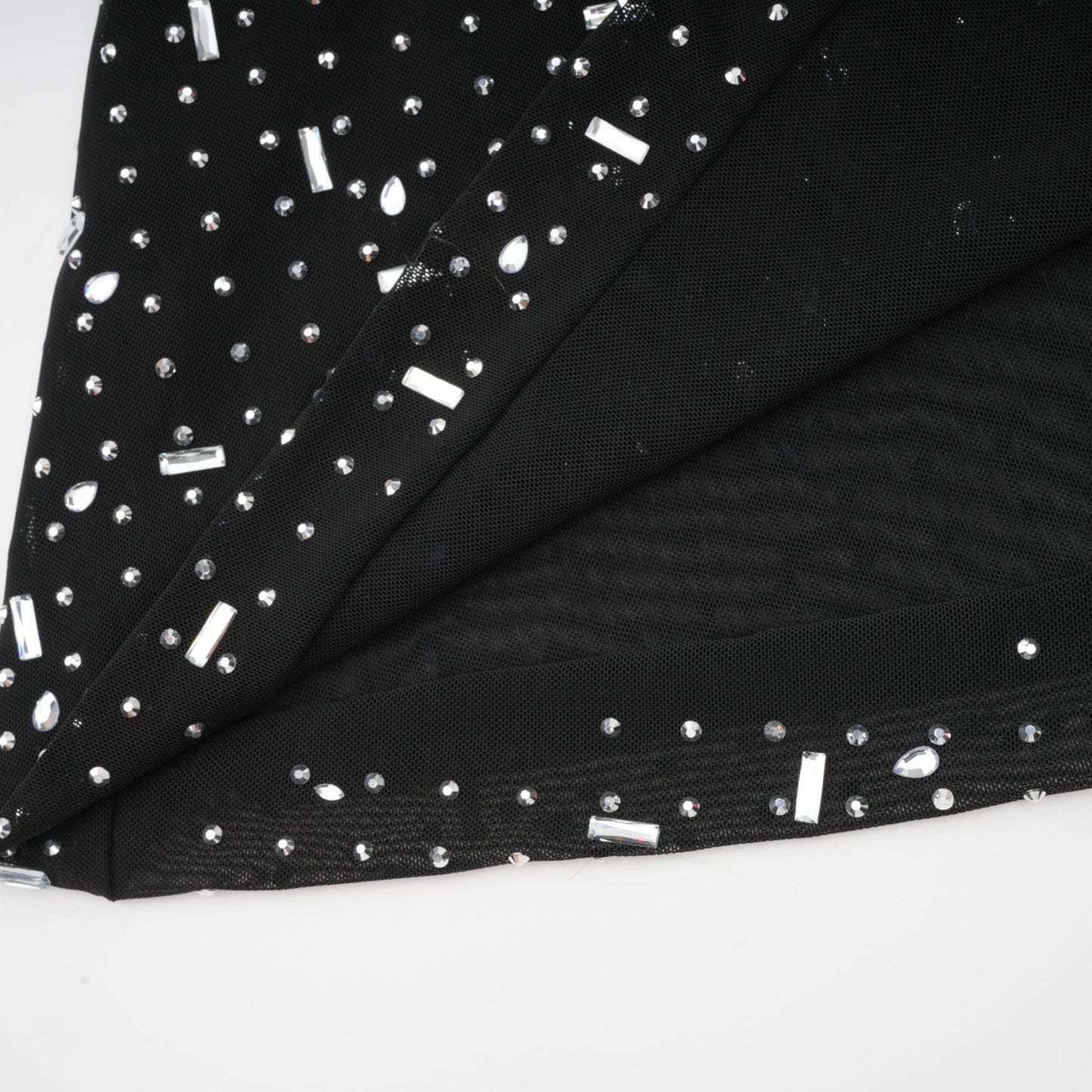 A black floor length maxi dress with sheer fabric and embellished details worn by a model