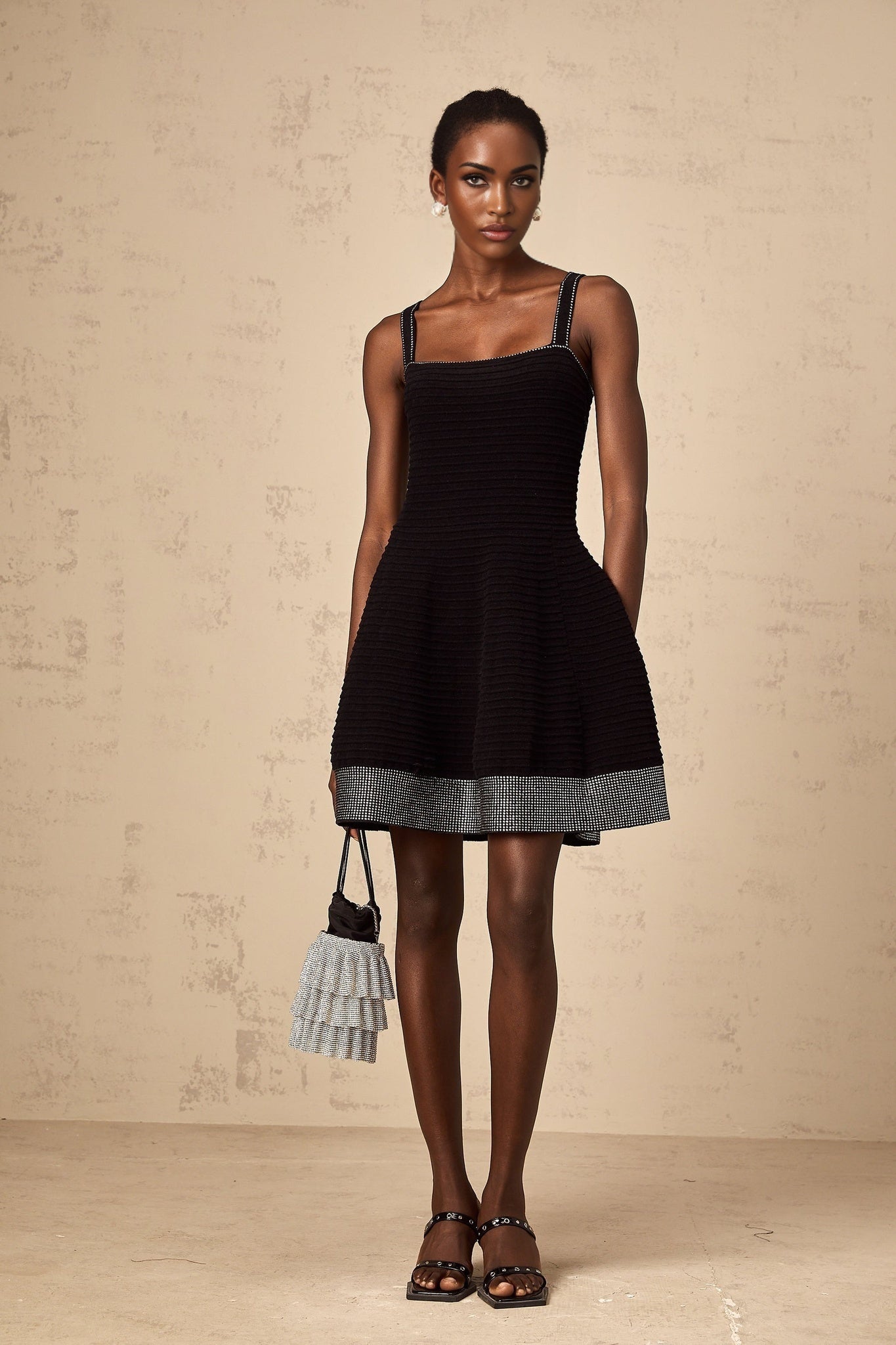 A black knit mini dress with flared skirt and studded details named Eliane