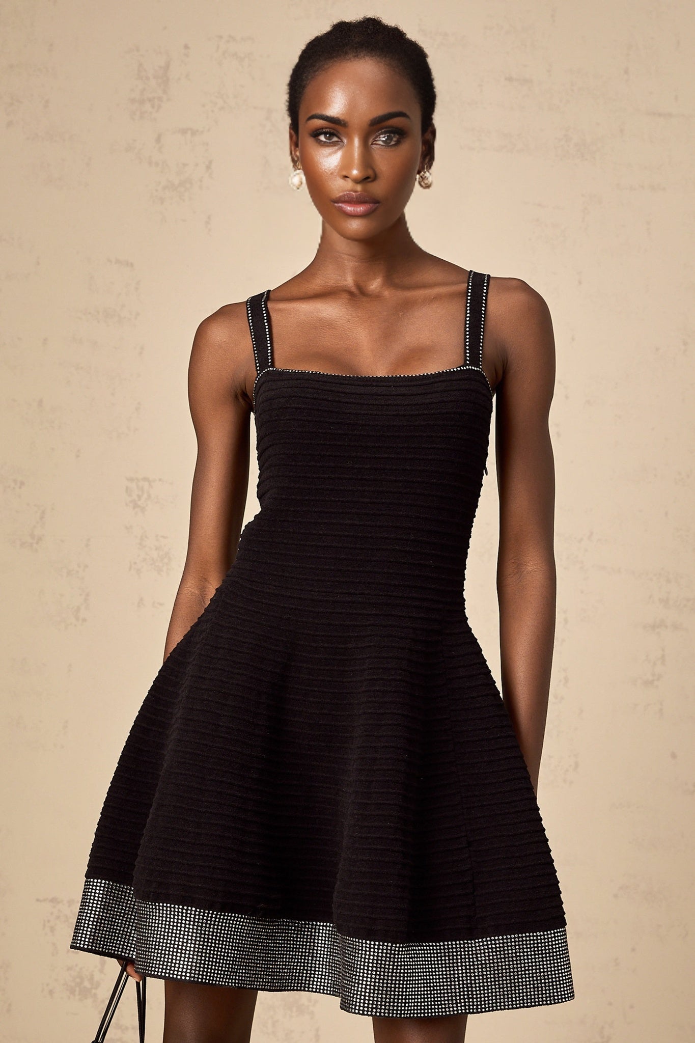 A black knit mini dress with flared skirt and studded details named Eliane