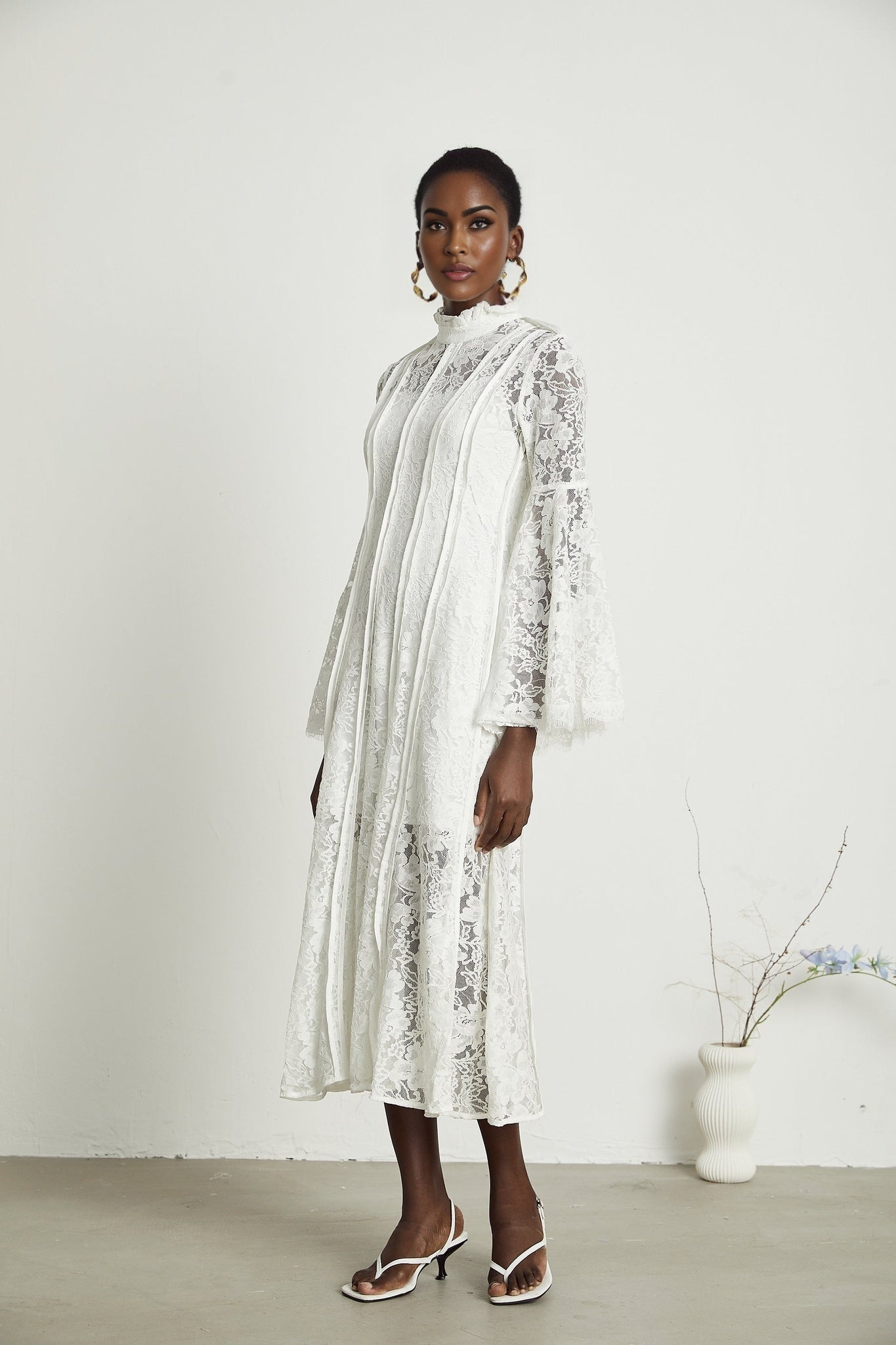 A black lace midi dress by Celine featuring cutout details and delicate floral patterns