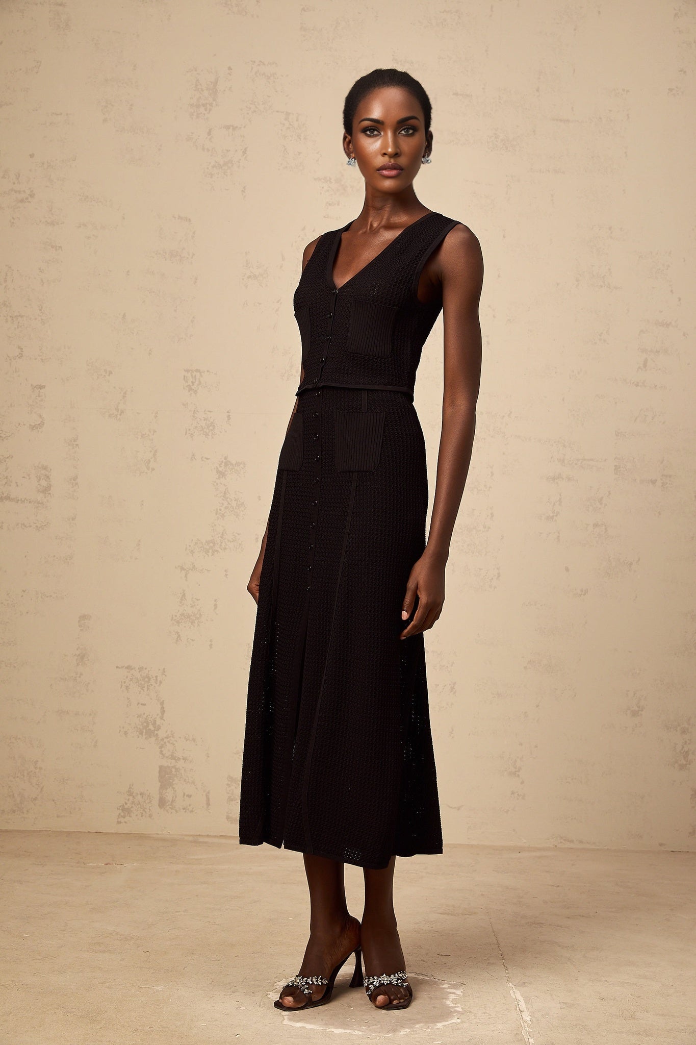 A black matching set consisting of a pointelleknit top and skirt named Babette The top and skirt feature a delicate openwork pattern The set offers a coordinated and stylish look for various occasions