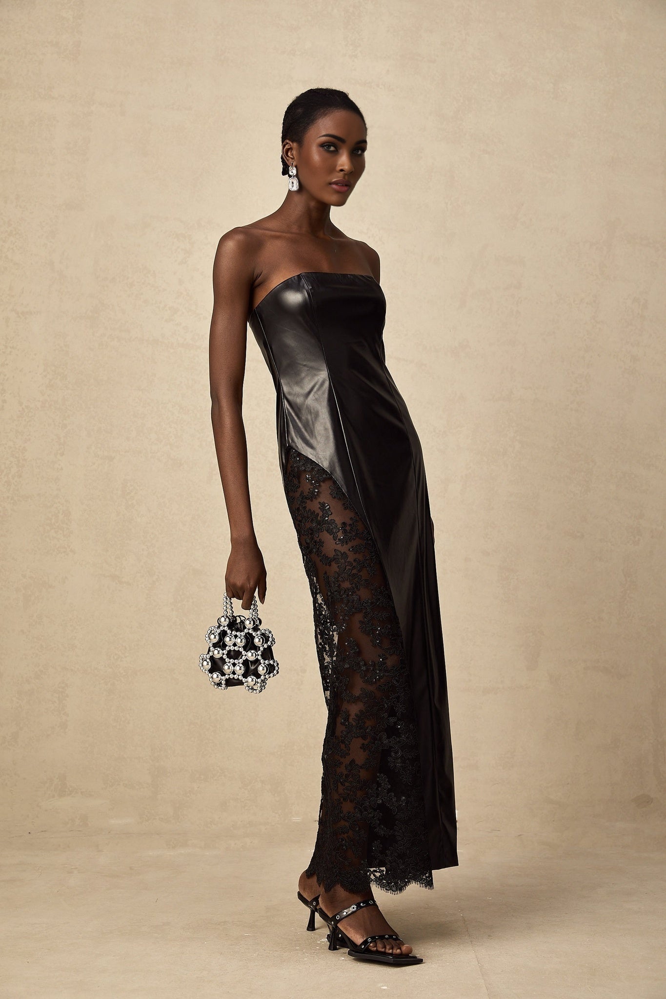 A black maxi dress with faux leather material and lace panel detailing named Angelique