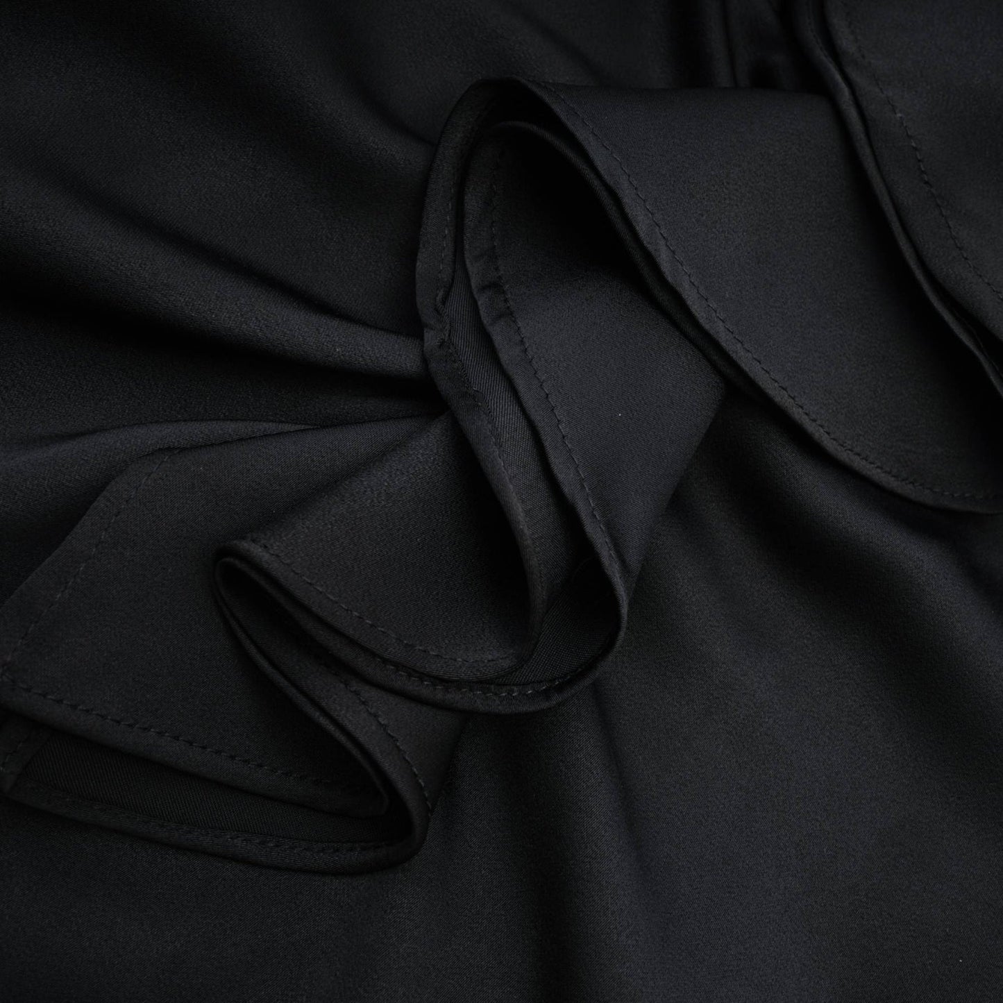 A sleeveless black dress with spaghetti straps flower decoration at the neck ankle length open back and made of 100% polyester