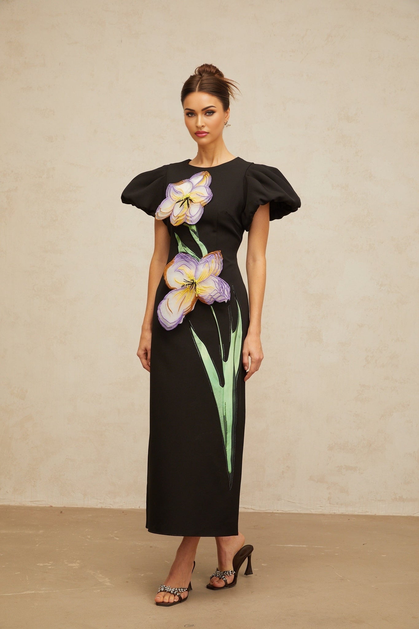A black midi dress with sequin embellishments and floral embroidery featuring long sleeves and a fitted silhouette
