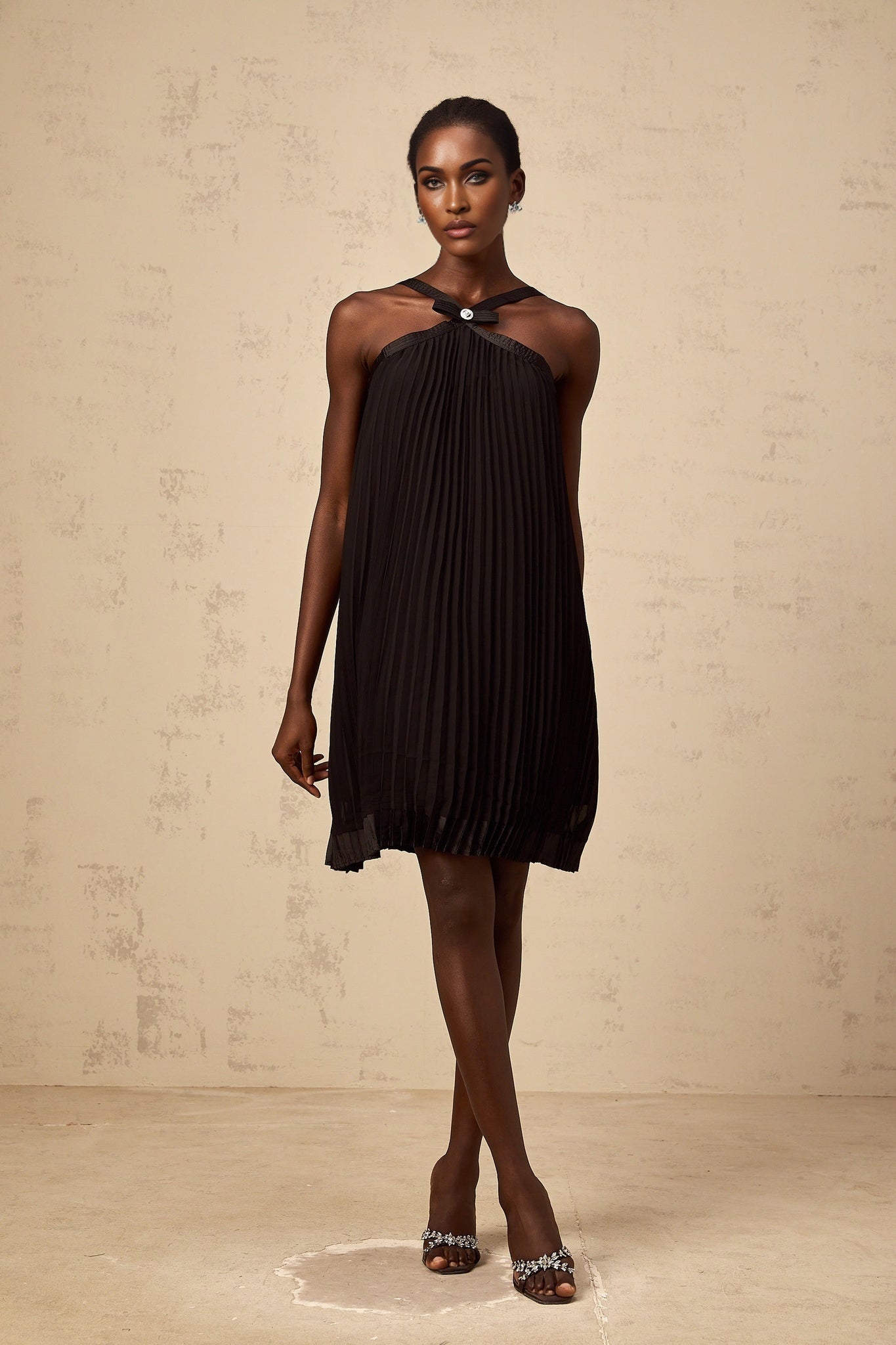 A black mini dress with a pleated skirt and a large bow accent at the waist inspired by the Zelda video game series