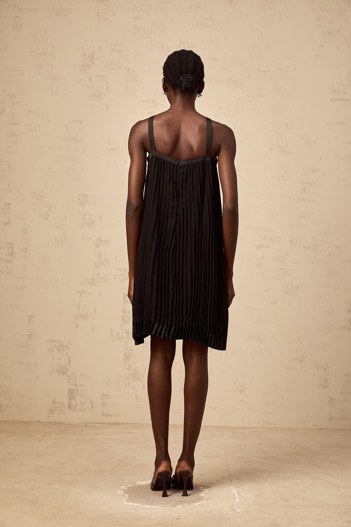 A black mini dress with a pleated skirt and a large bow detail at the waist inspired by the Zelda video game series
