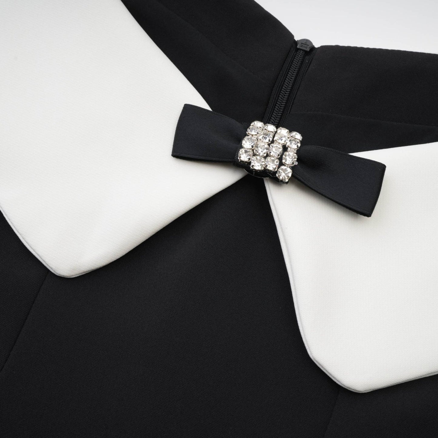 Black mini dress with a reversible collar off the shoulder style paneled design contrast colors spaghetti straps pleated detailing front bowknot 82% Cotton 18% Silk composition