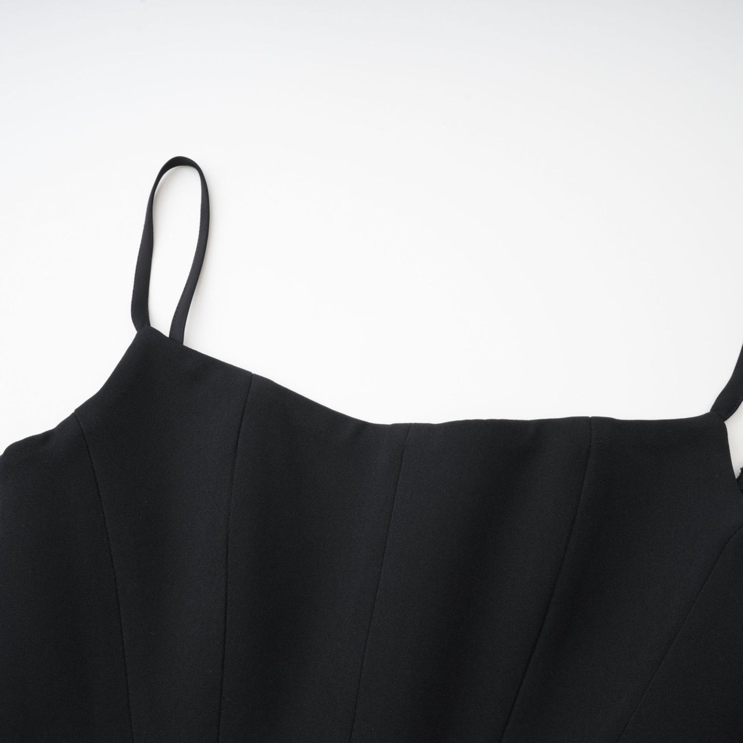 A black sleeveless dress with spaghetti straps square neck and a draped design Rear zip fastening and mini length 80% Polyester 20% Cotton