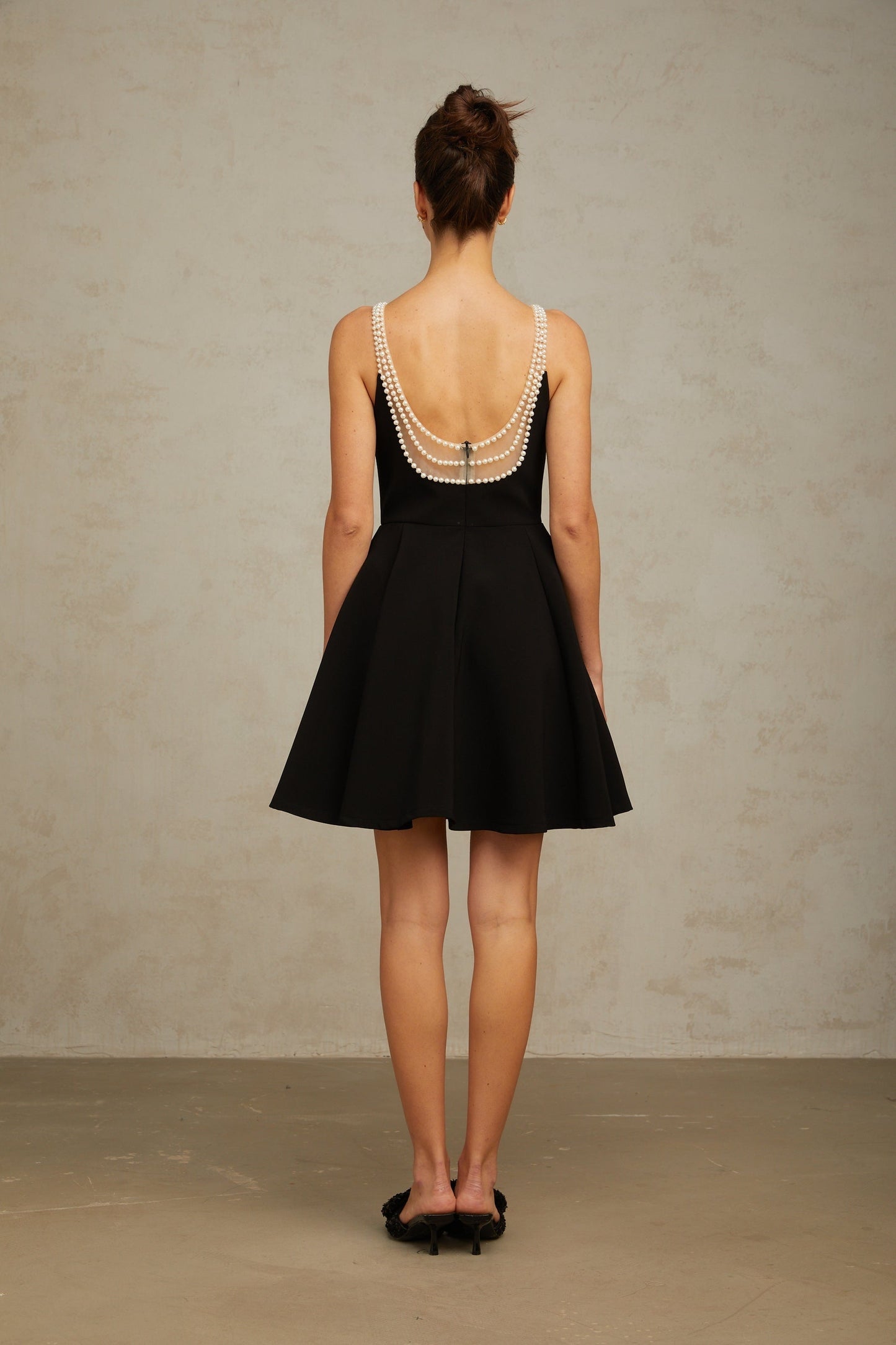 A black mini dress with faux pearl embellishments called Danae