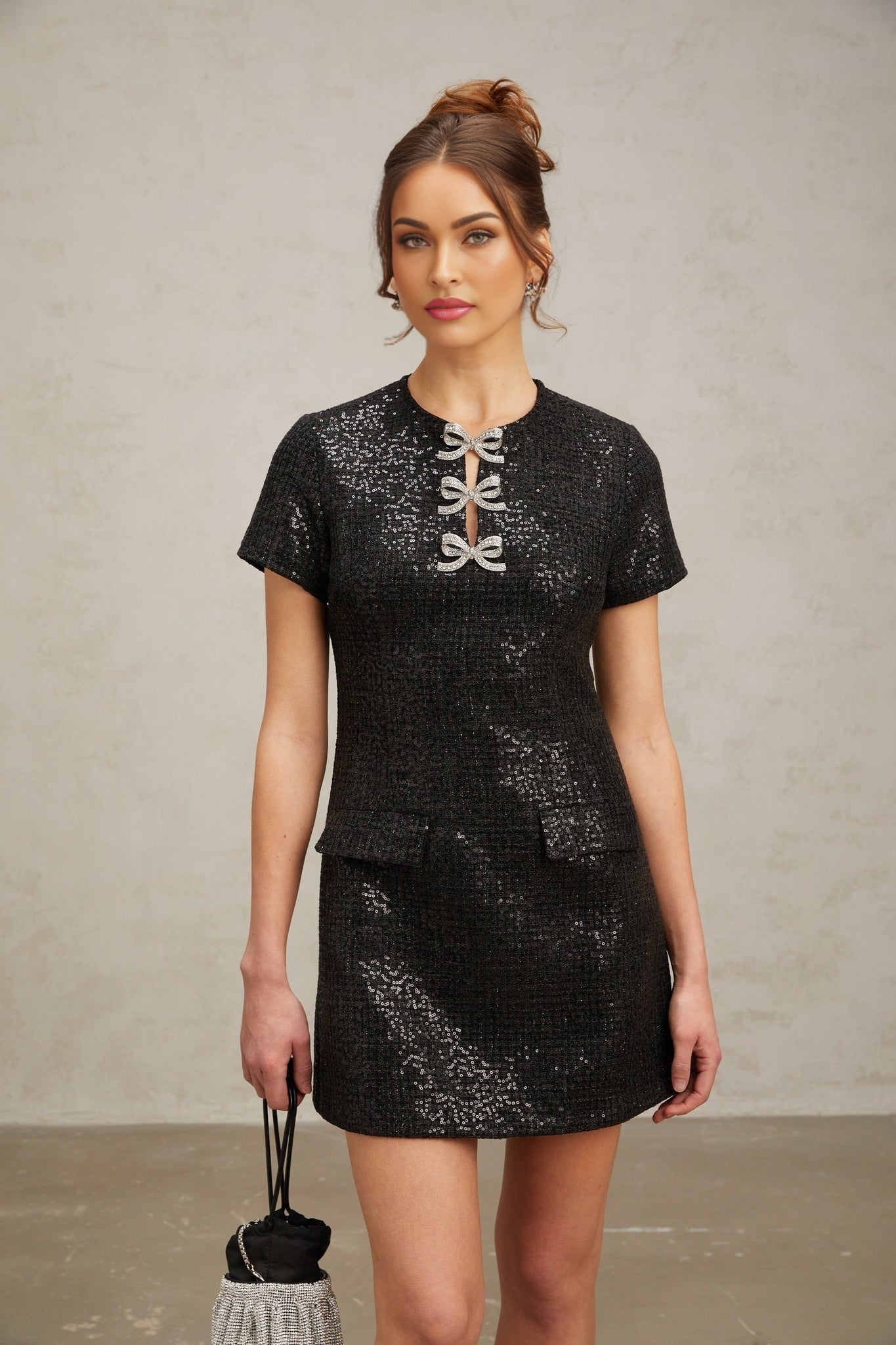 A black mini dress with glitter details and a short hemline