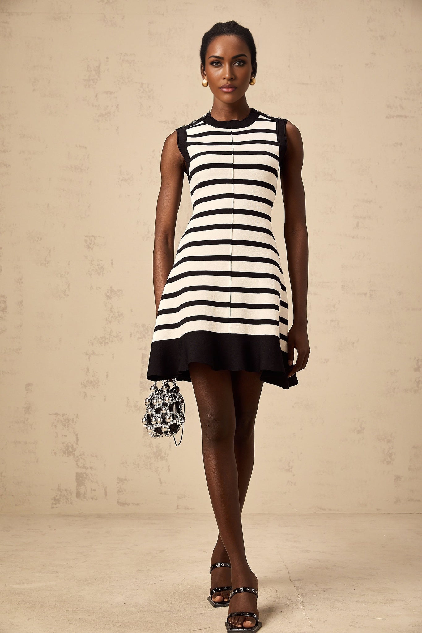 A black mini dress with horizontal stripes in a knit fabric featuring a short hemline and a fitted silhouette