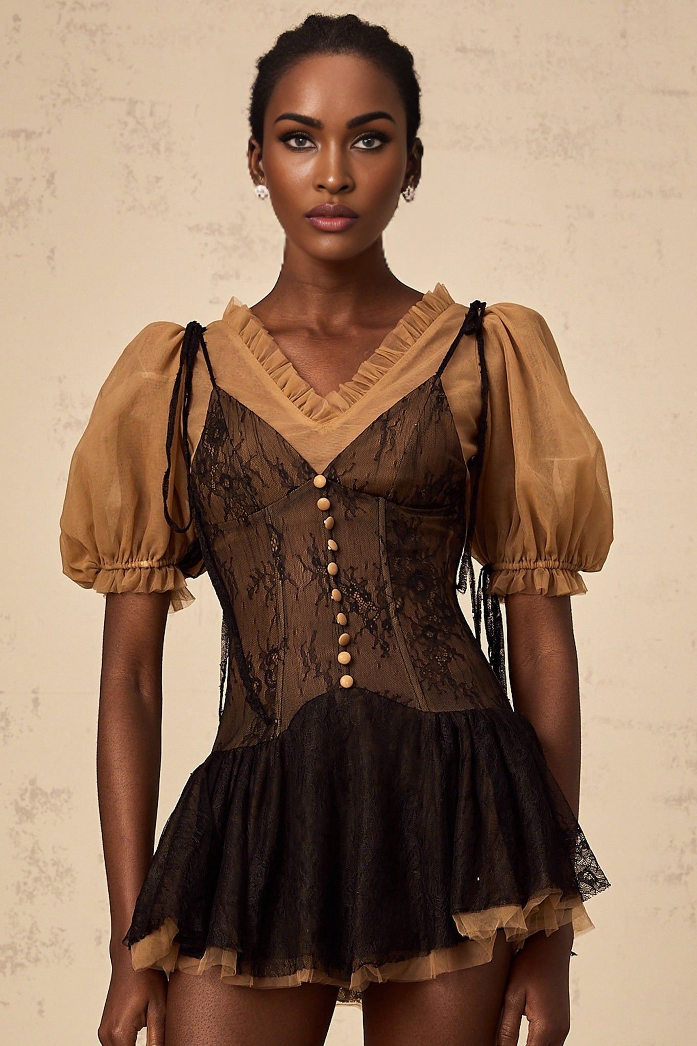 A black mini dress with lace panel detailing featuring a sleek silhouette and delicate feminine design