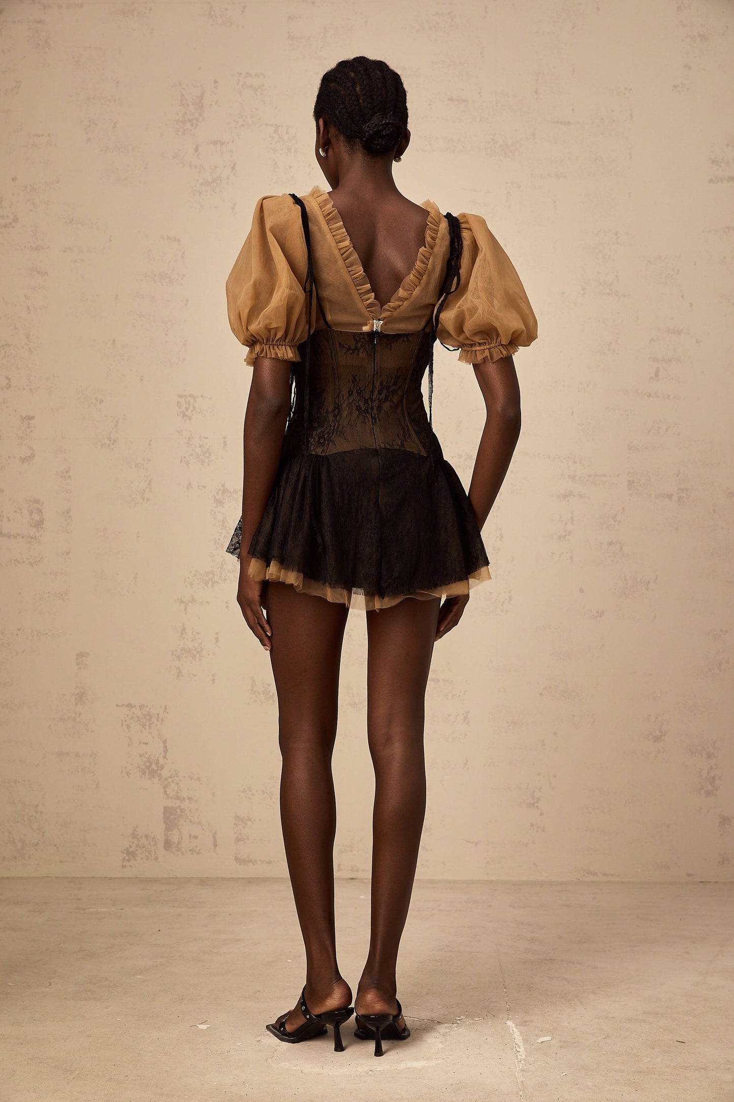 A black mini dress with lace panelling details and a fitted silhouette