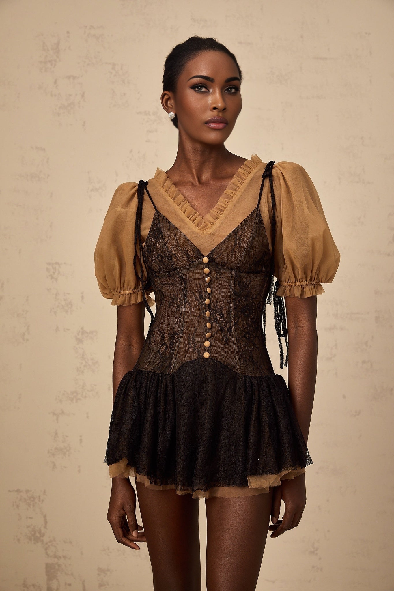 A black mini dress with lace panels featuring a short hemline and delicate lace detailing throughout the design