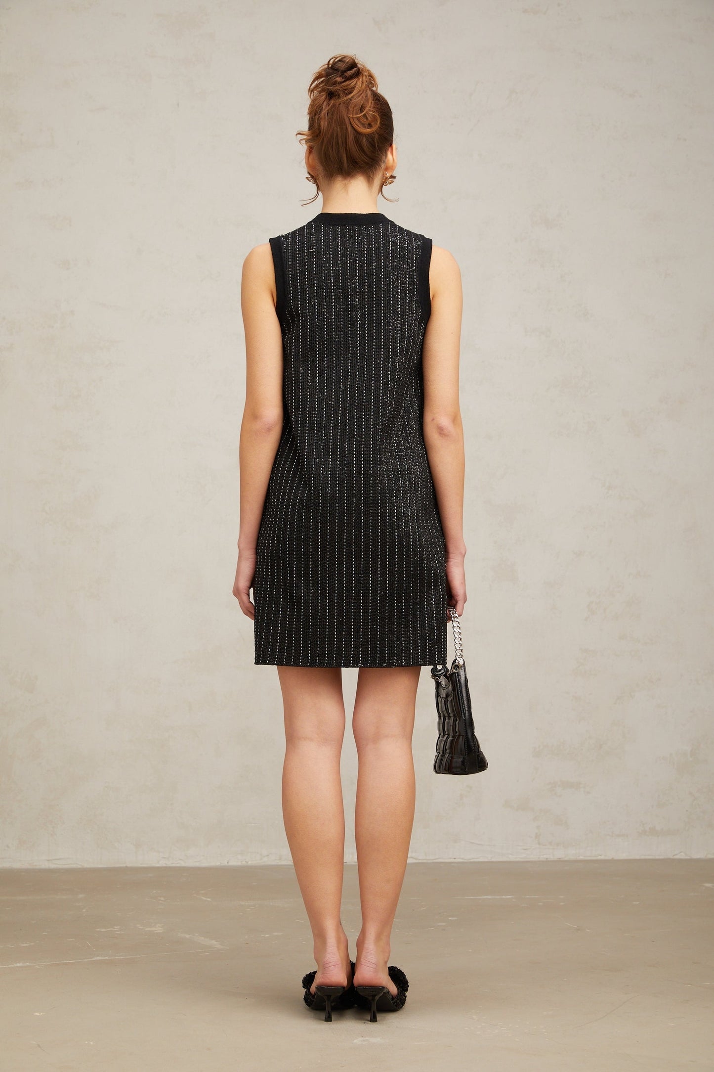 A black mini dress with vertical stripes and sequin embellishments featuring a knit fabric and a short hemline inspired by Zelda style