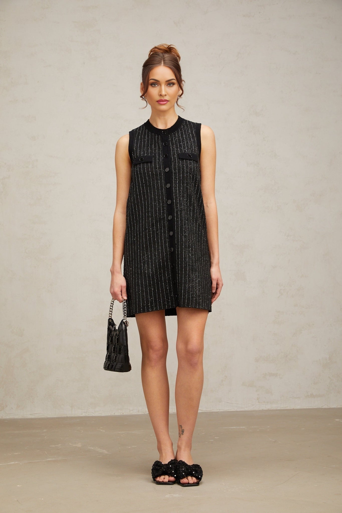 A black mini dress with vertical stripes and sequin embellishments featuring a knit fabric and short hemline inspired by Zelda style