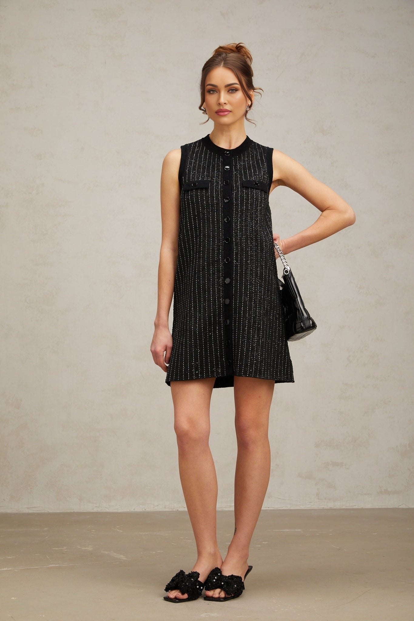 A black mini dress with vertical stripes made of sequins and knit fabric featuring a Zelda design