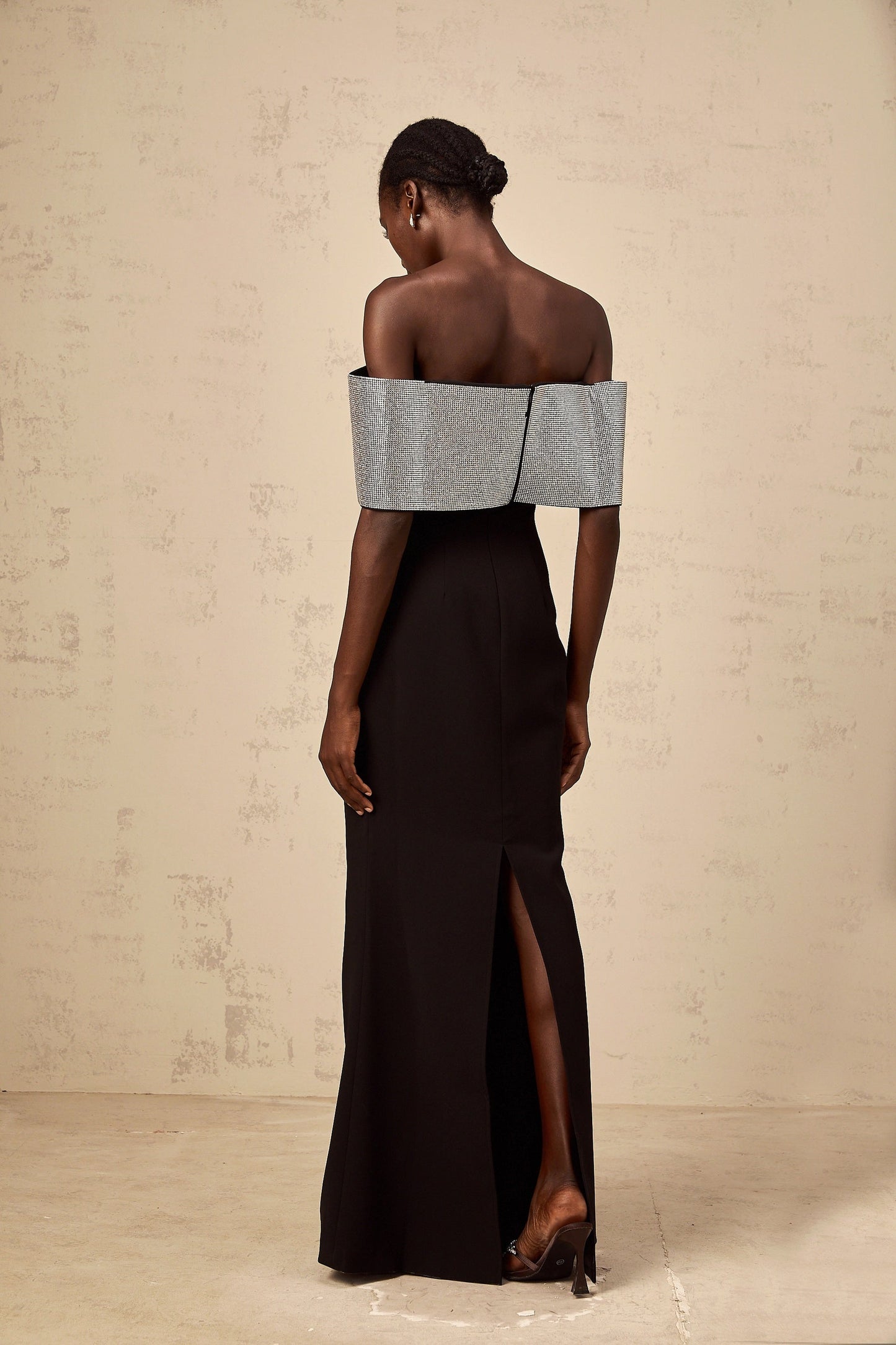 A black offshoulder maxi dress by Chloé featuring a rhinestone bow detail