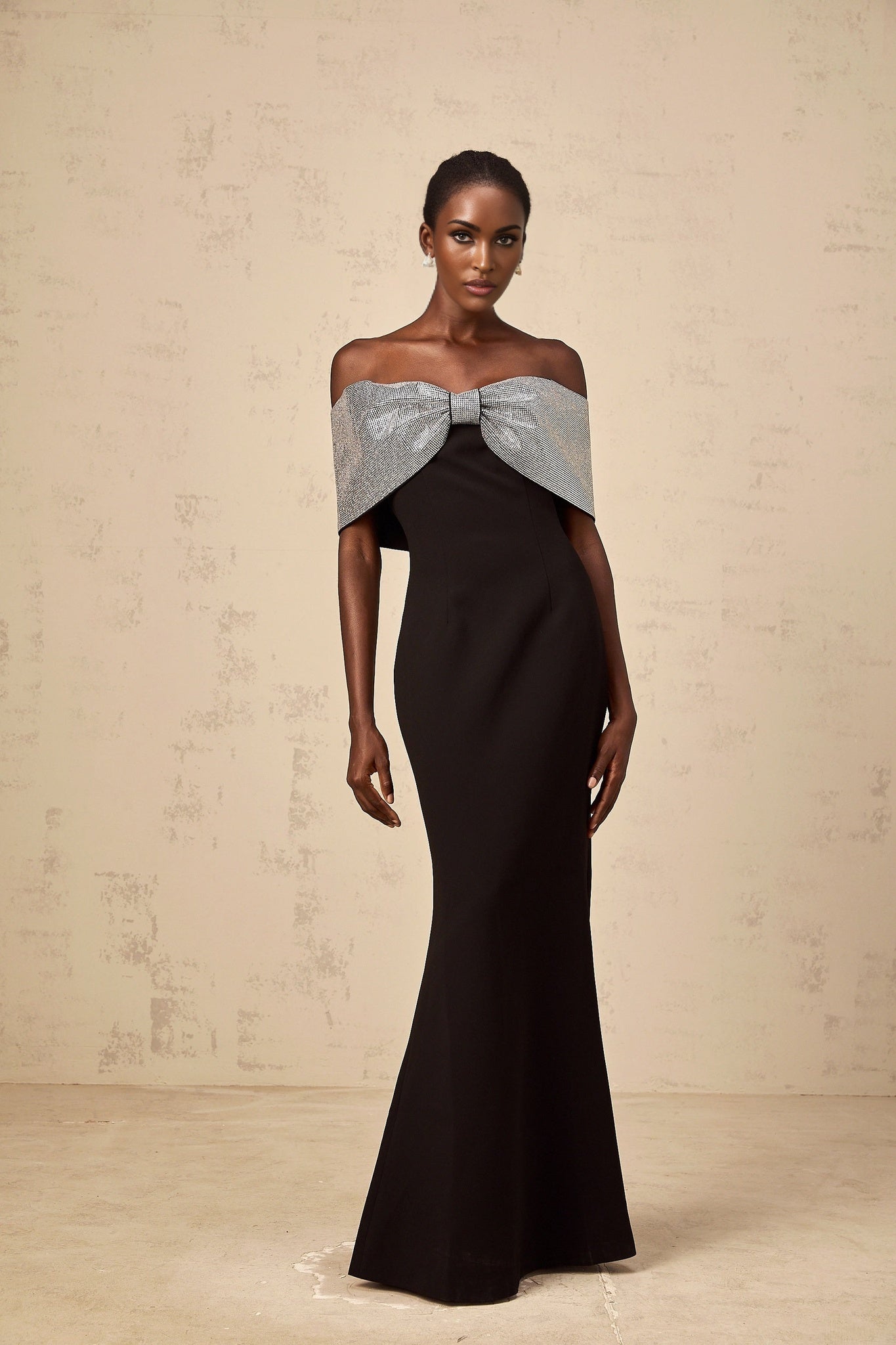 A black offshoulder maxi dress by Chloé featuring a rhinestone bow detail