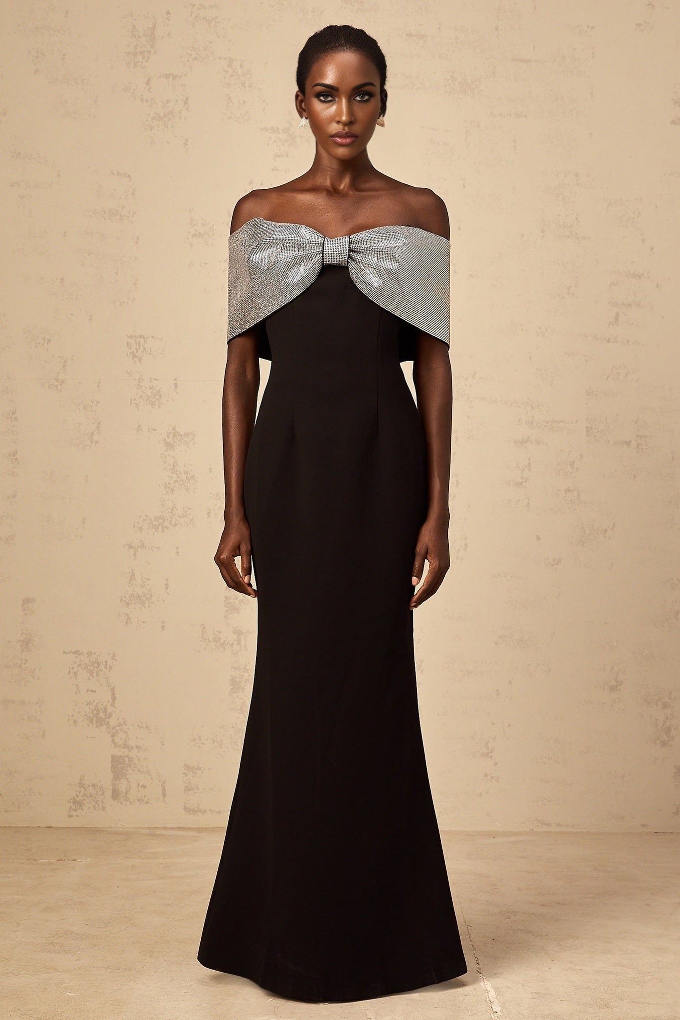 A black offshoulder maxi dress with a rhinestone bow detail by Chloé