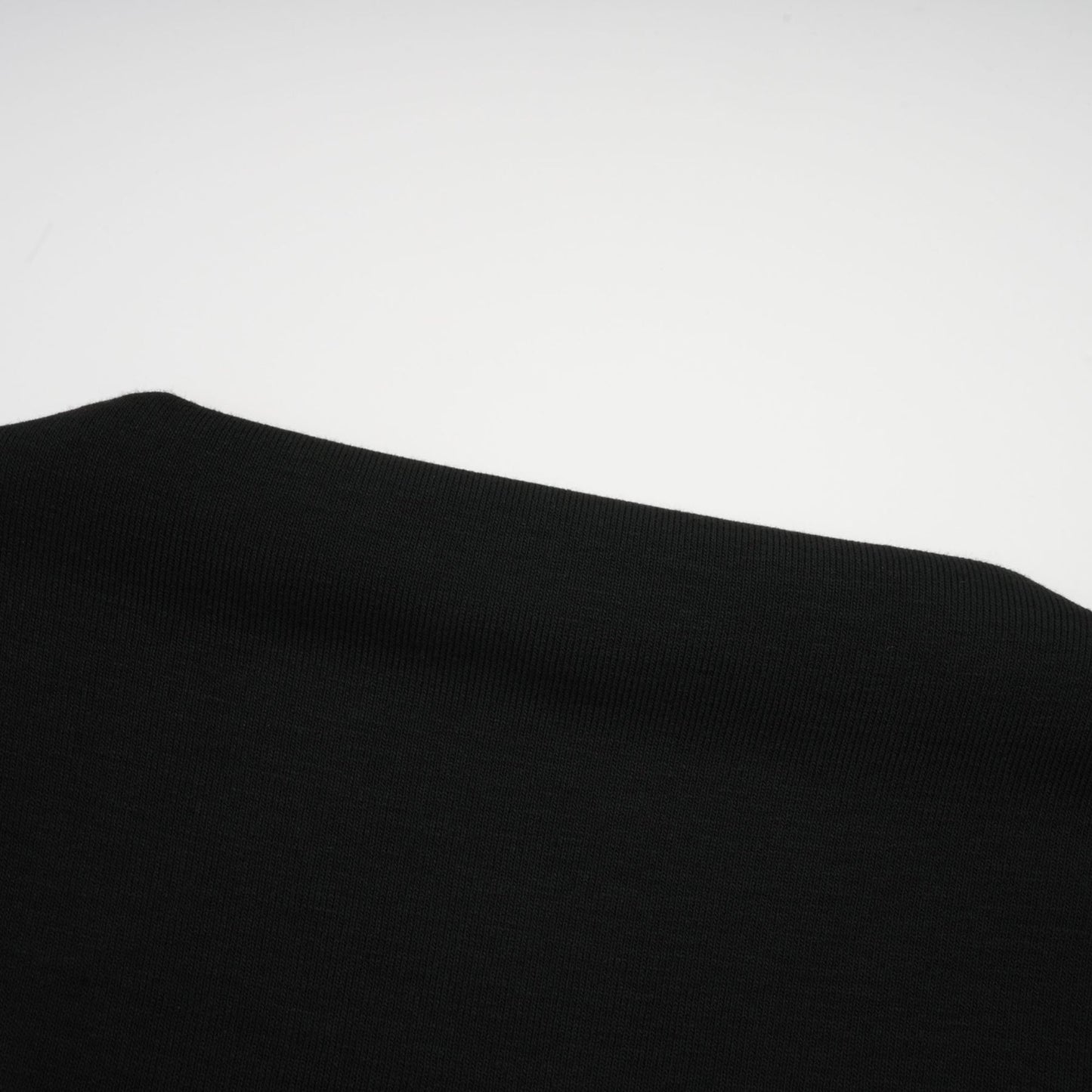 A black sleeveless top with an open front design and gathered fabric details