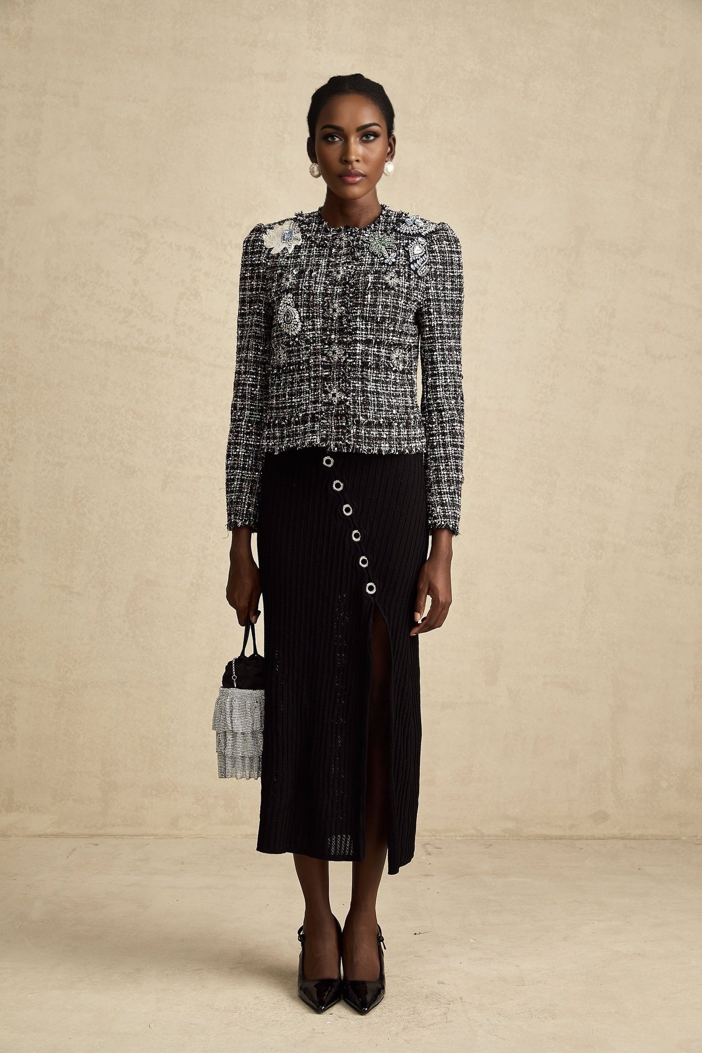 A black tweed jacket with a checkered pattern and frayed edges named Justine