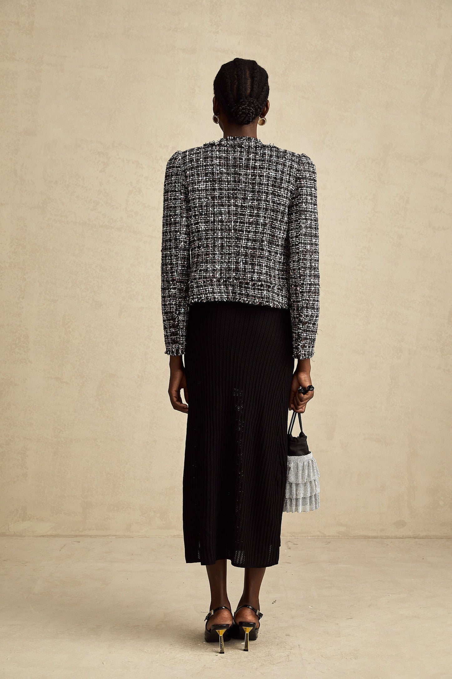 A black tweed jacket with a frayed edge and checkered pattern called Justine