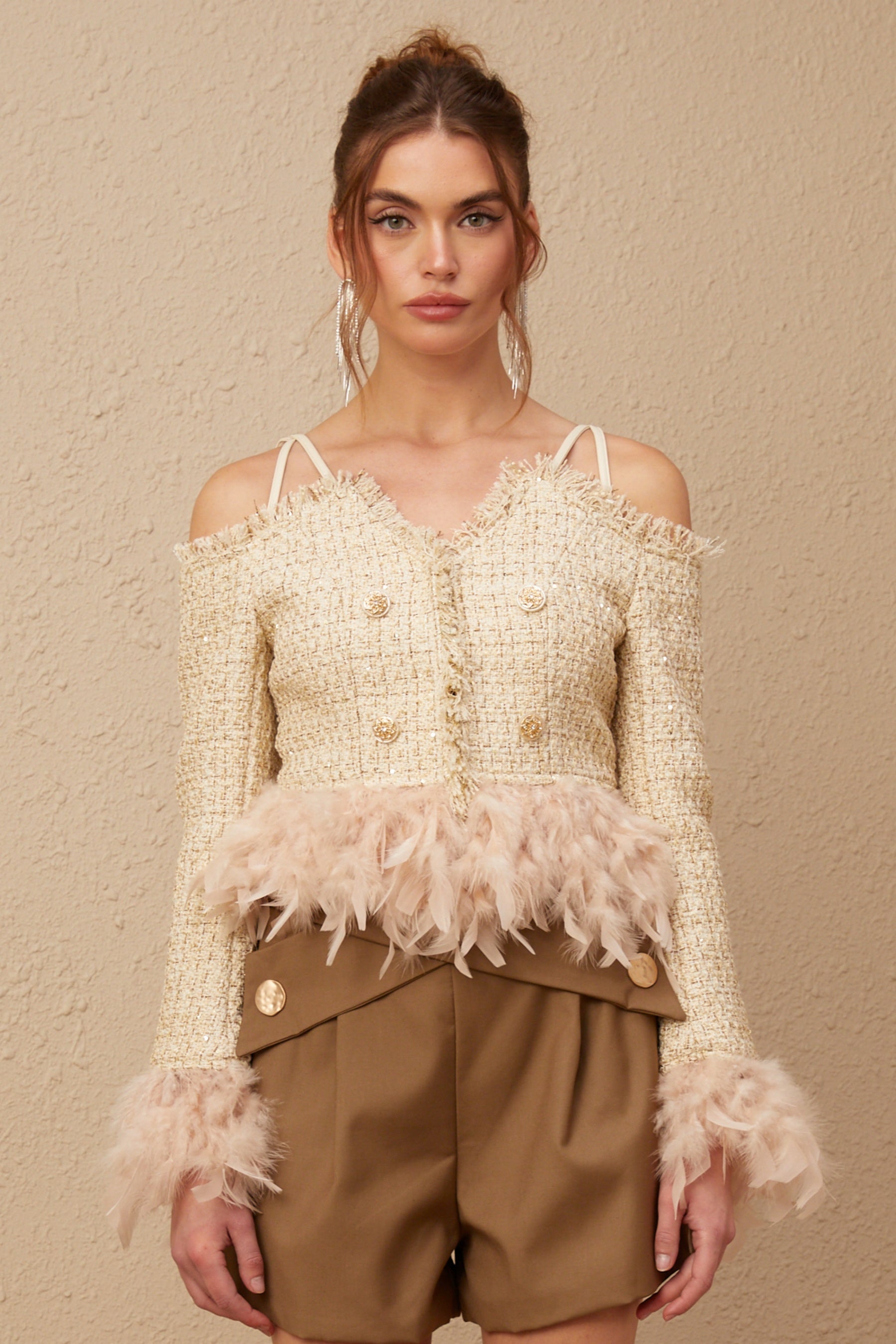 A black tweed offshoulder top with white feather trim along the neckline and cuffs named Laetiecia