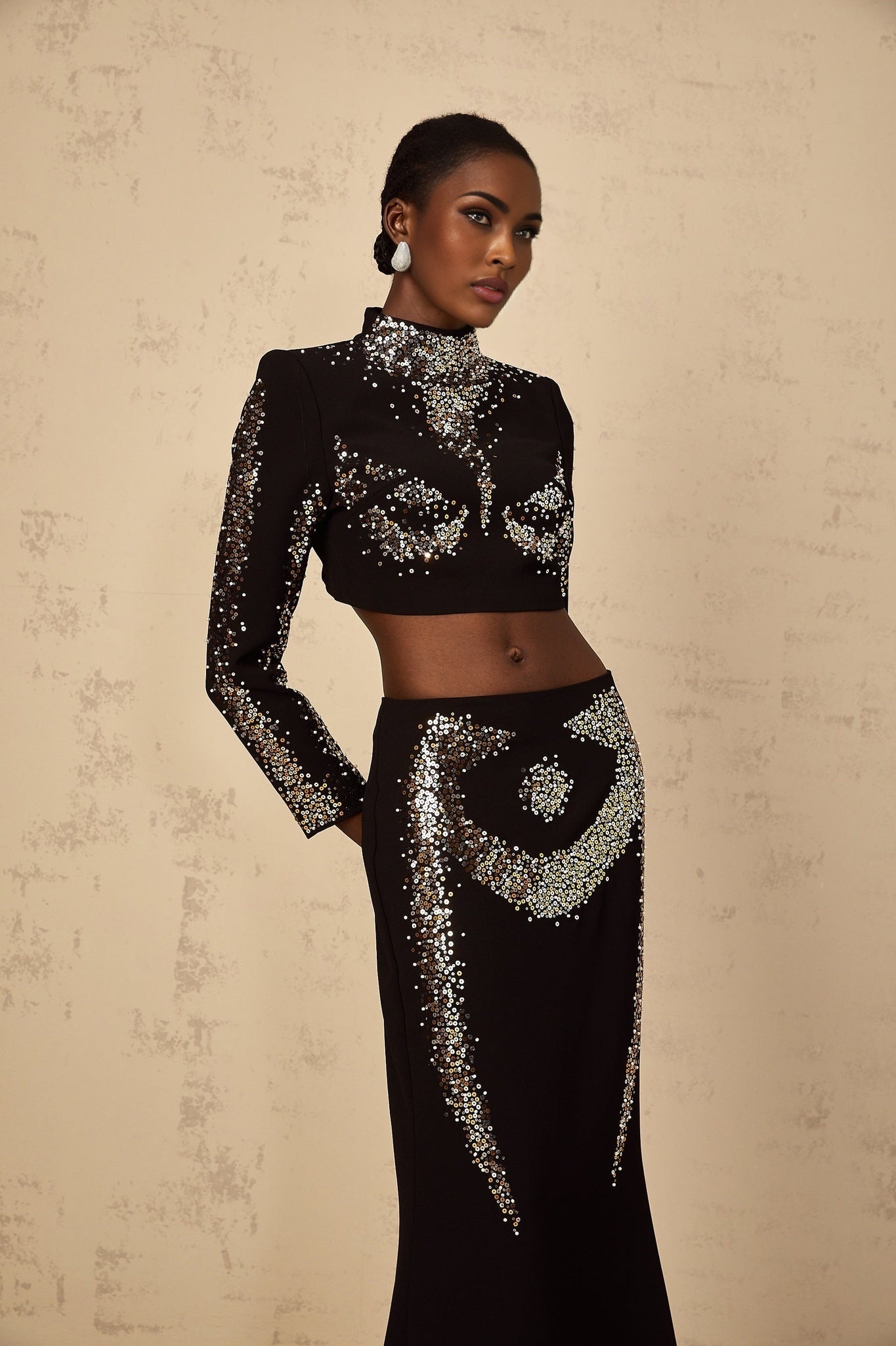 A black twopiece outfit featuring a top and skirt set adorned with sequin embellishments called the Mahault set