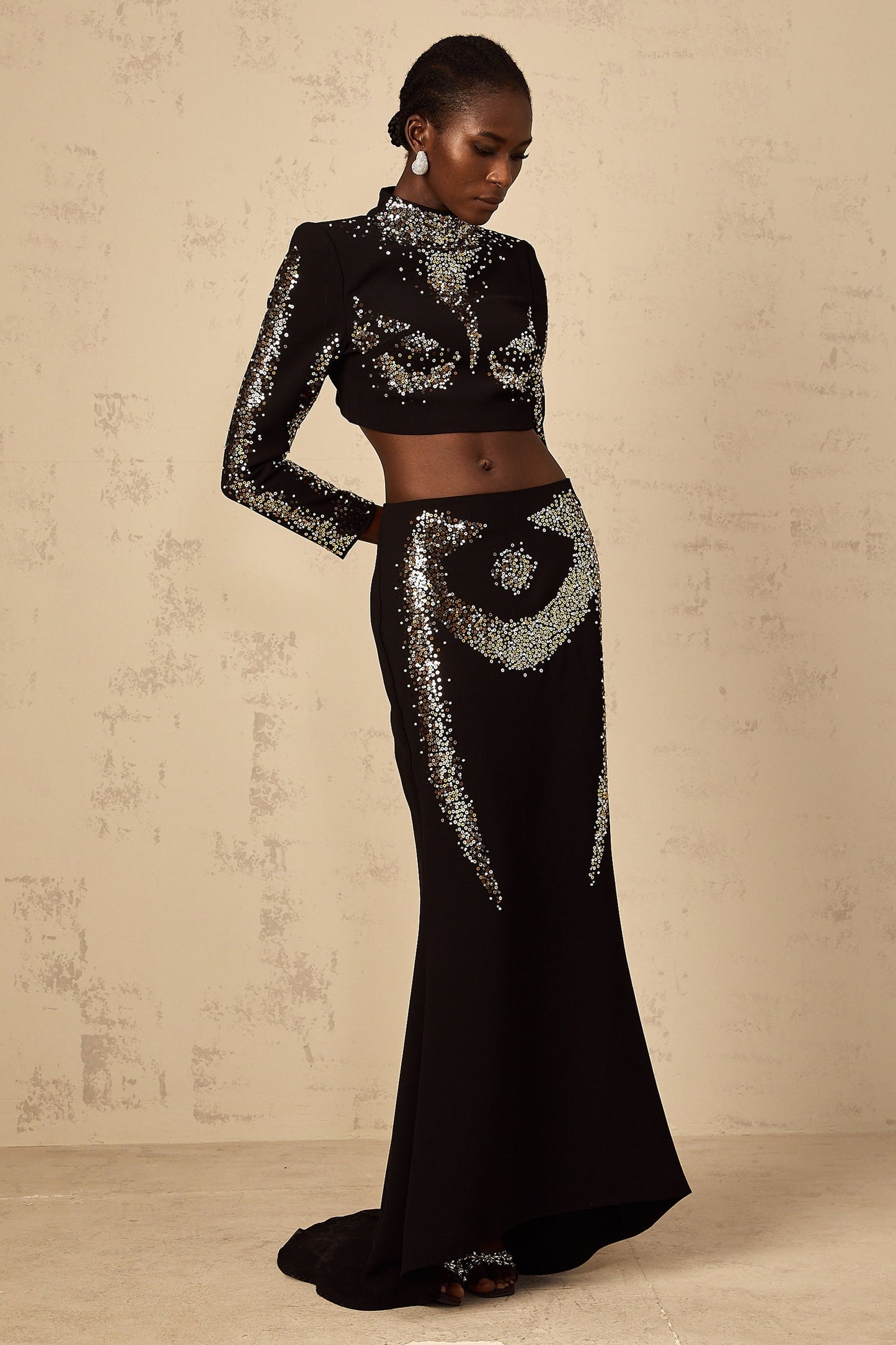 A black twopiece outfit featuring a top and skirt set adorned with sequin embellishments named Mahault
