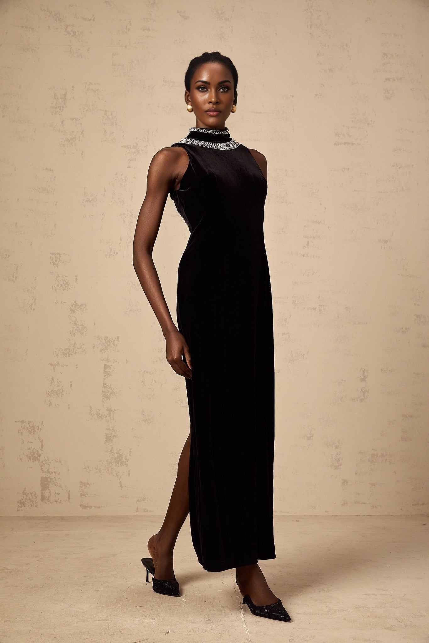 A black velvet gown with crystal embellishments named Colette displayed on a mannequin or model