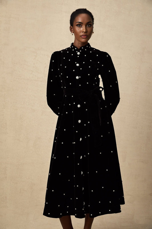 A black velvet midi dress with embellishments named Lola on a plain background