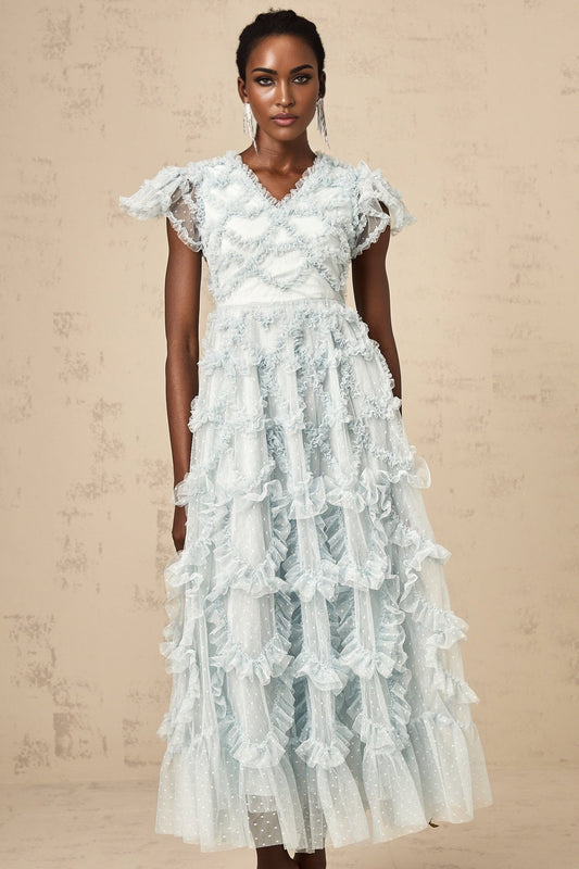 A blue midi dress with ruffle details and small dot pattern named Corinna