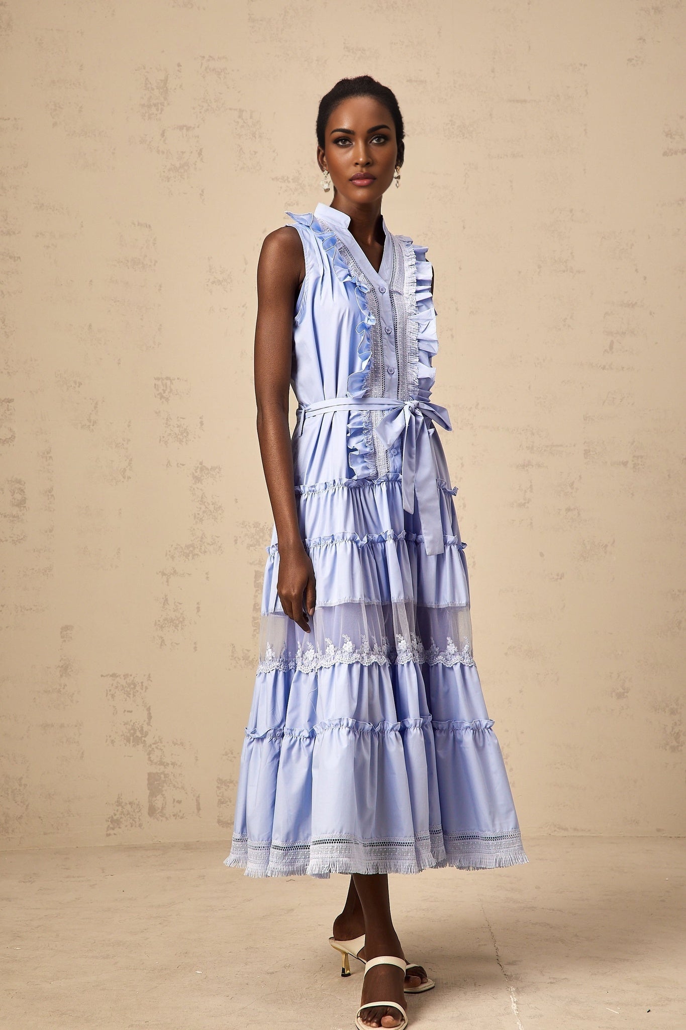 A blue midi dress with ruffles and floral lace trim featuring a tiered skirt design called Olena